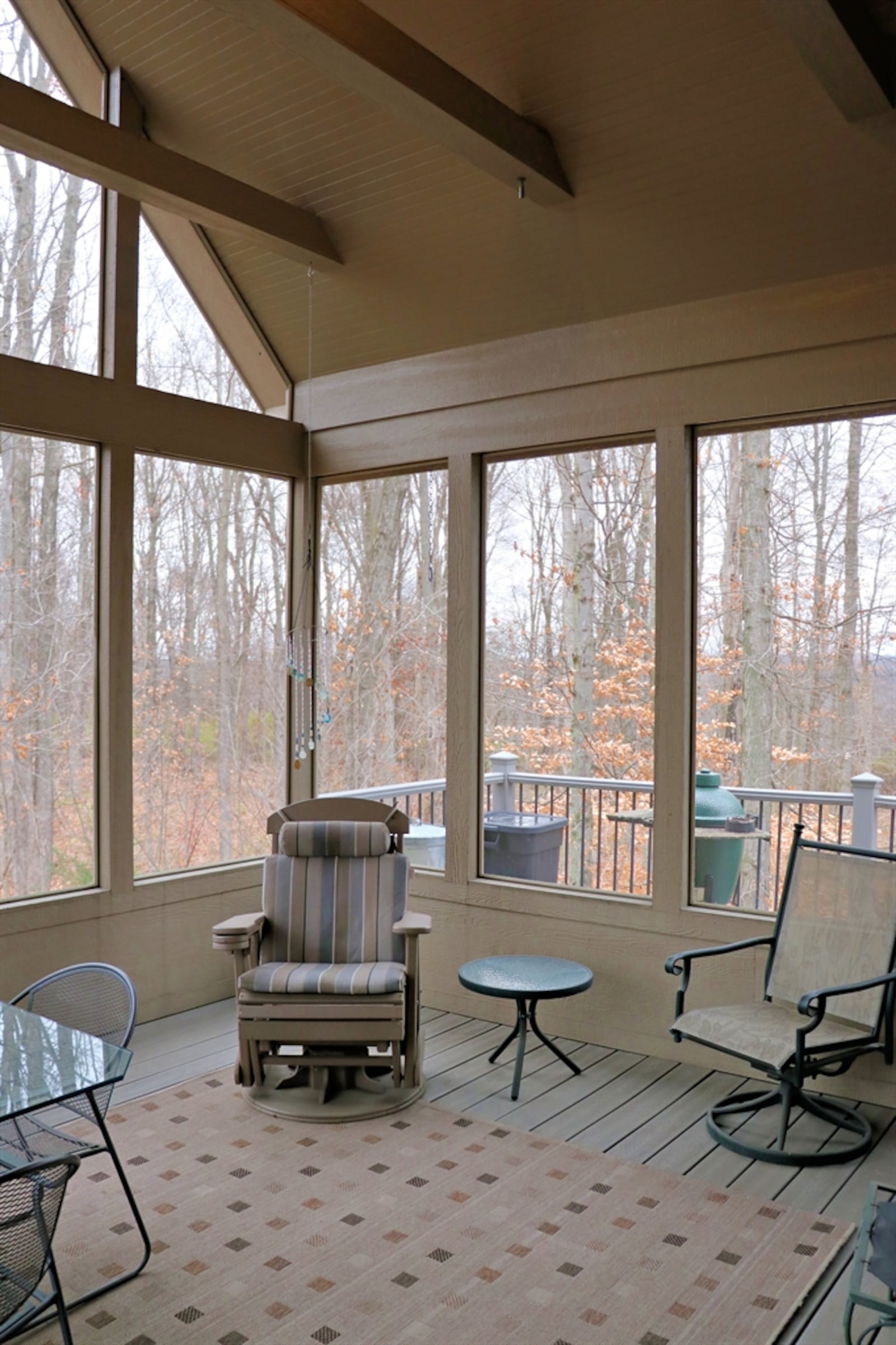 The porch has a cathedral ceiling with cross beams and a paddle fan.