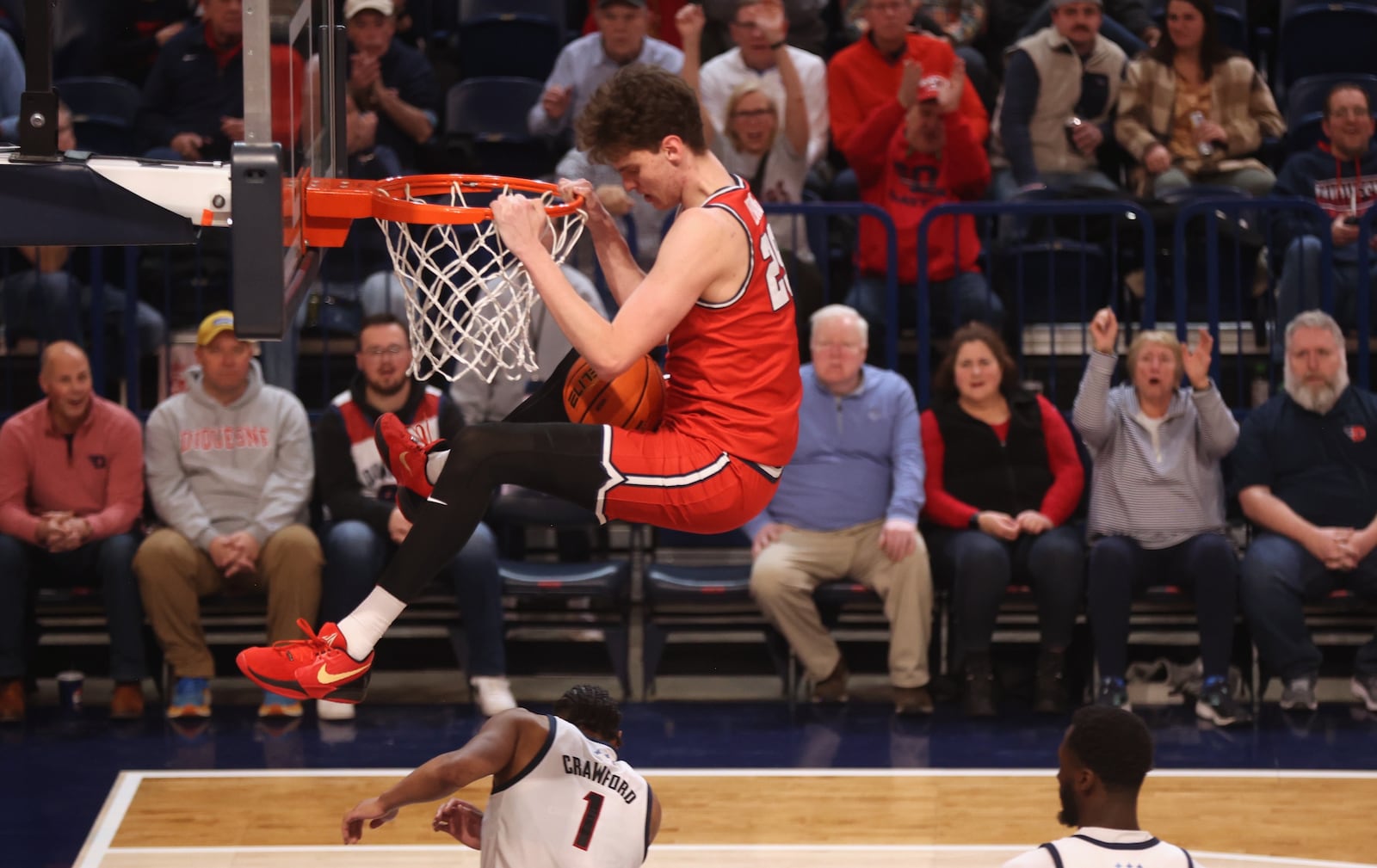 Dayton's Amaël L'Etang hangs on the rim after a dunk against Duquesne and earns a technical foul in the second half on Tuesday, Jan. 21, 2025, at the UPMC Cooper Fieldhouse in Pittsburgh. David Jablonski/Staff