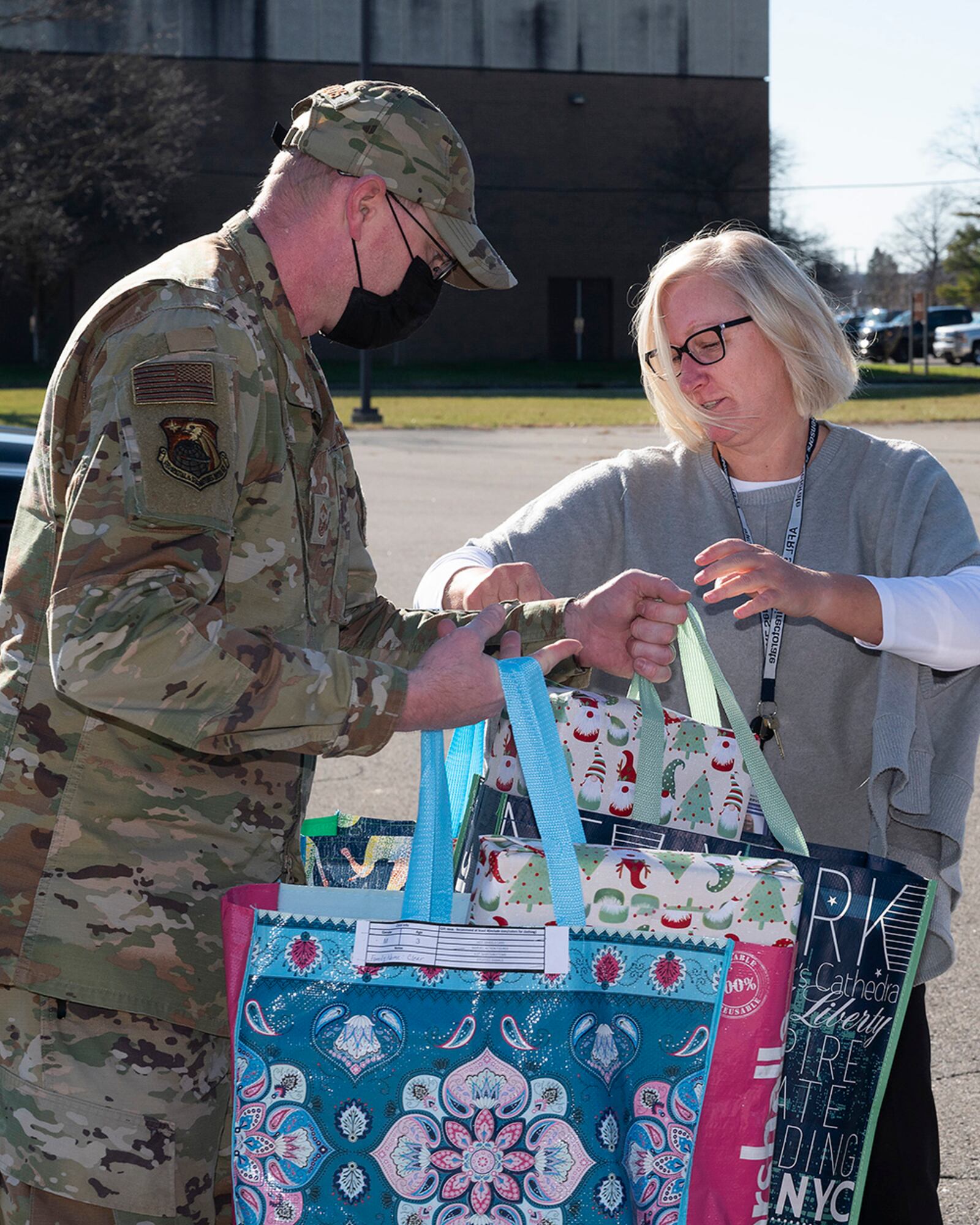 Senior Master Sgt. Timothy Sigafoos, National Air and Space Intelligence Center first sergeant, receives donated gifts from Lisa Maciejewski, Air Force Research Laboratory, for the First Sergeants Council’s Adopt-A-Family Program on Dec. 3 at Wright-Patterson Air Force Base. First sergeants coordinate getting the donated gifts to a designated family without either the sponsors or recipients knowing who the other is. U.S. AIR FORCE PHOTO/R.J. ORIEZ