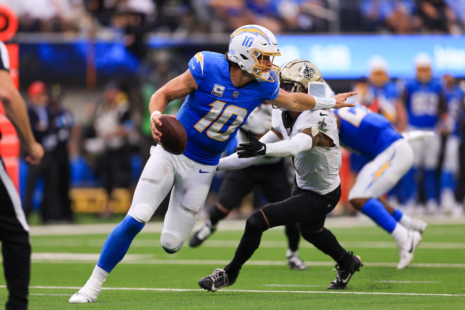 Los Angeles Chargers quarterback Justin Herbert (10) carries against New Orleans Saints cornerback Alontae Taylor in the second half of an NFL football game in Inglewood, Calif., Sunday, Oct. 27, 2024. (AP Photo/Ryan Sun)