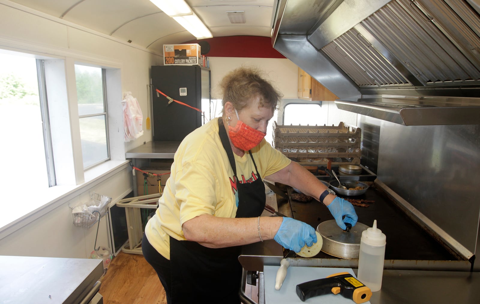 Cathy Bell cooks up food in the McNasty's food truck, a fixture on Dayton's Courthouse Square for eight years. LISA POWELL / STAFF