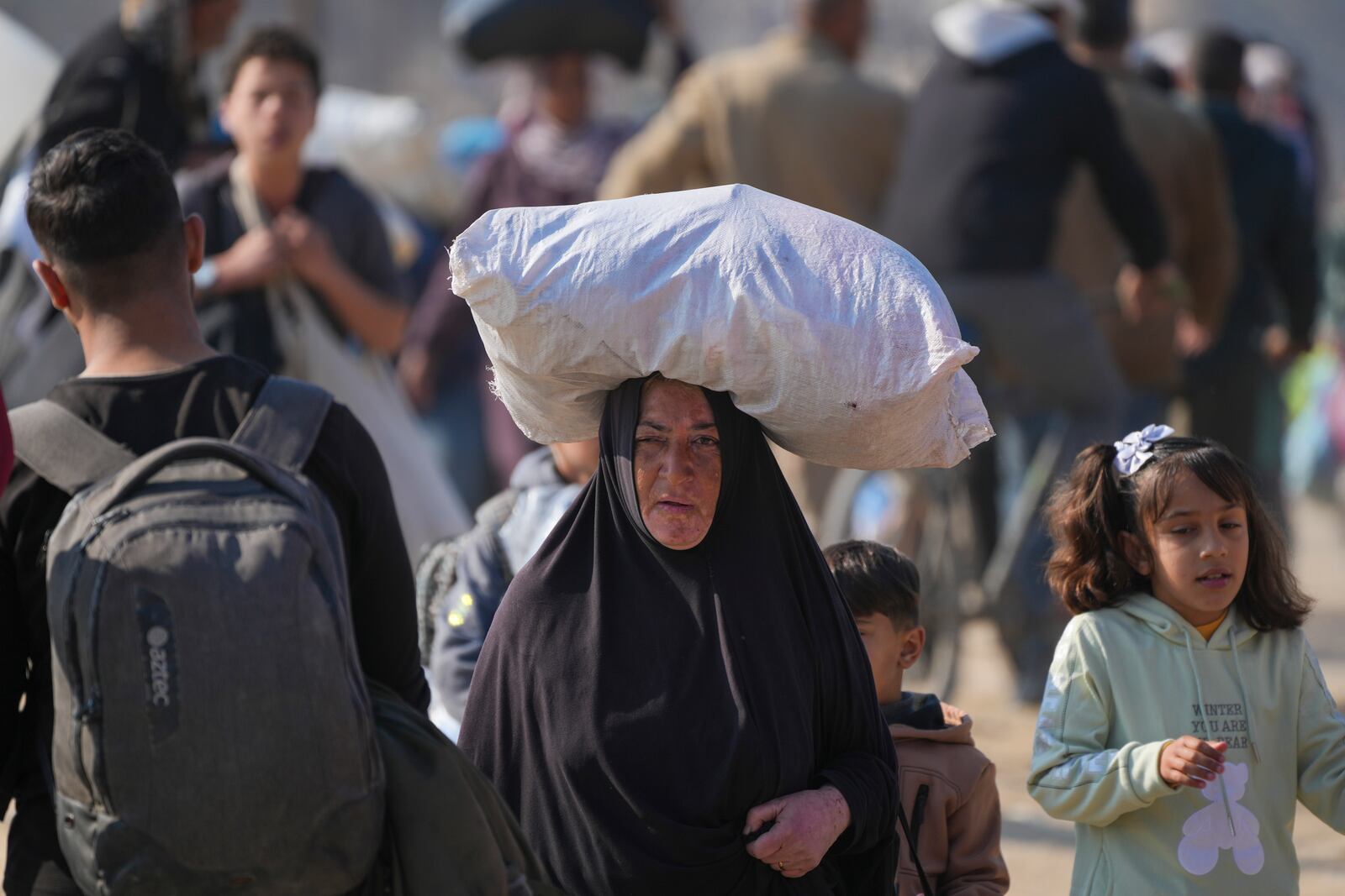 Displaced Palestinians walk on a road in central Gaza to return to their homes in the northern Gaza Strip, Wednesday, Jan. 29, 2025. (AP Photo/Abdel Kareem Hana)