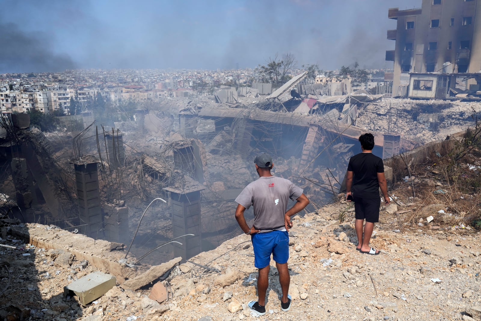 FILE - People check a building damaged by an Israeli airstrike in Choueifat, Lebanon, Sept. 28, 2024. (AP Photo/Hussein Malla, File)