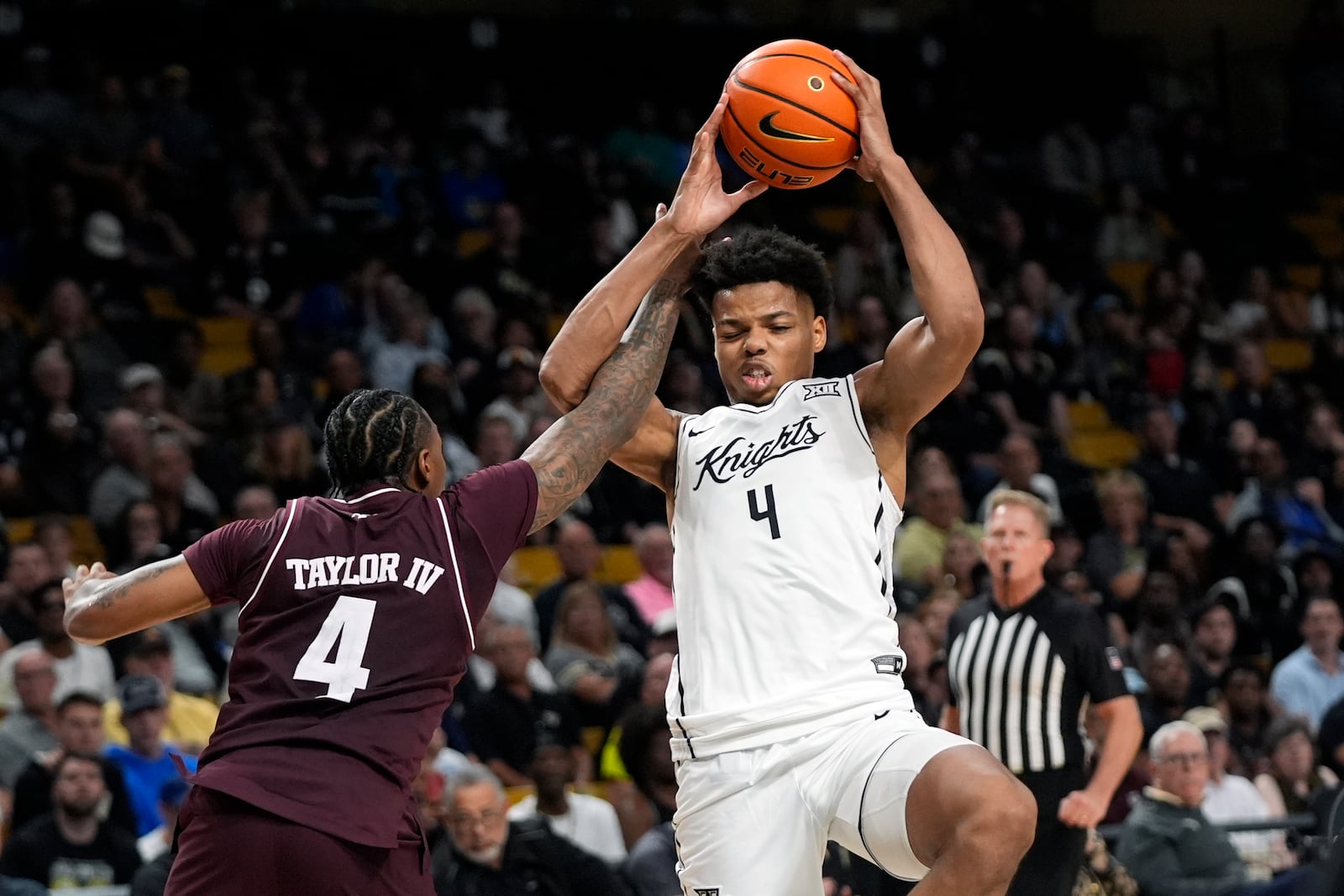 Texas A&M guard Wade Taylor IV, left, fouls Central Florida guard Keyshawn Hall, right, who goes up to shoot during the second half of an NCAA college basketball game, Monday, Nov. 4, 2024, in Orlando, Fla. (AP Photo/John Raoux)