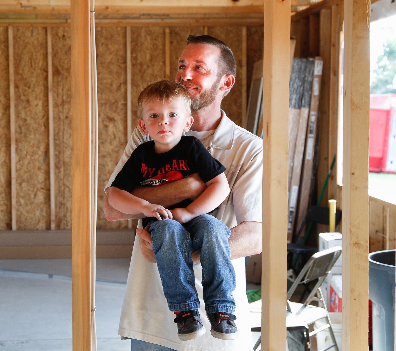 Kevin Pennington holds 2-year-old Owen in their Brookville home that is being rebuilt after it was destroyed by a tornado. Pennington’s wife Gloria and their other three children, Noah, 13, and 10-year-old twins, Ayden and Alyson, were also in the house where they huddled together on Memorial Day. CHRIS STEWART / STAFF