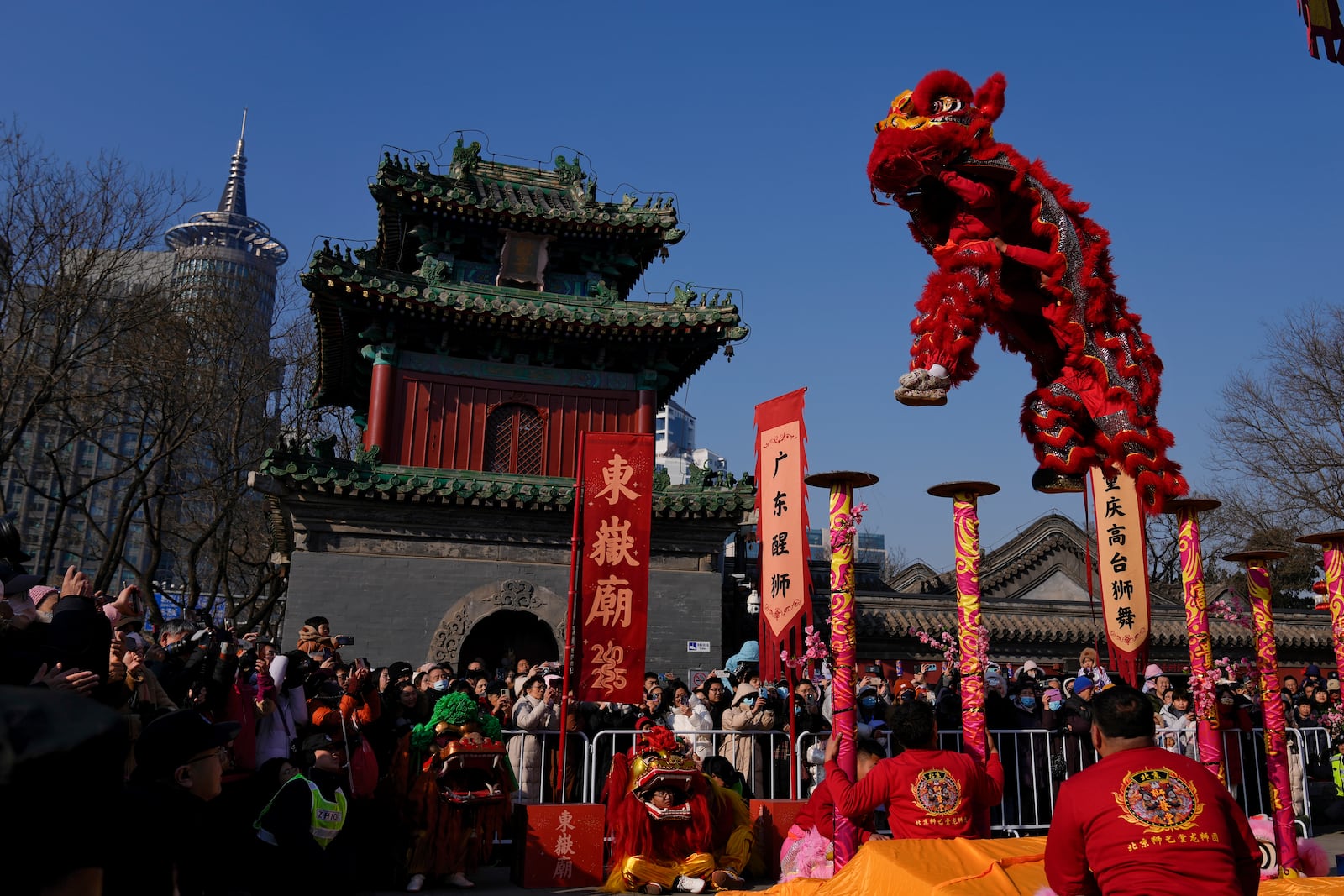 People watch as an artist performs an acrobatic lion dance at the Dongyue Temple on the first day of the Chinese Lunar New Year in Beijing on Wednesday, Jan. 29, 2025. (AP Photo/Andy Wong)