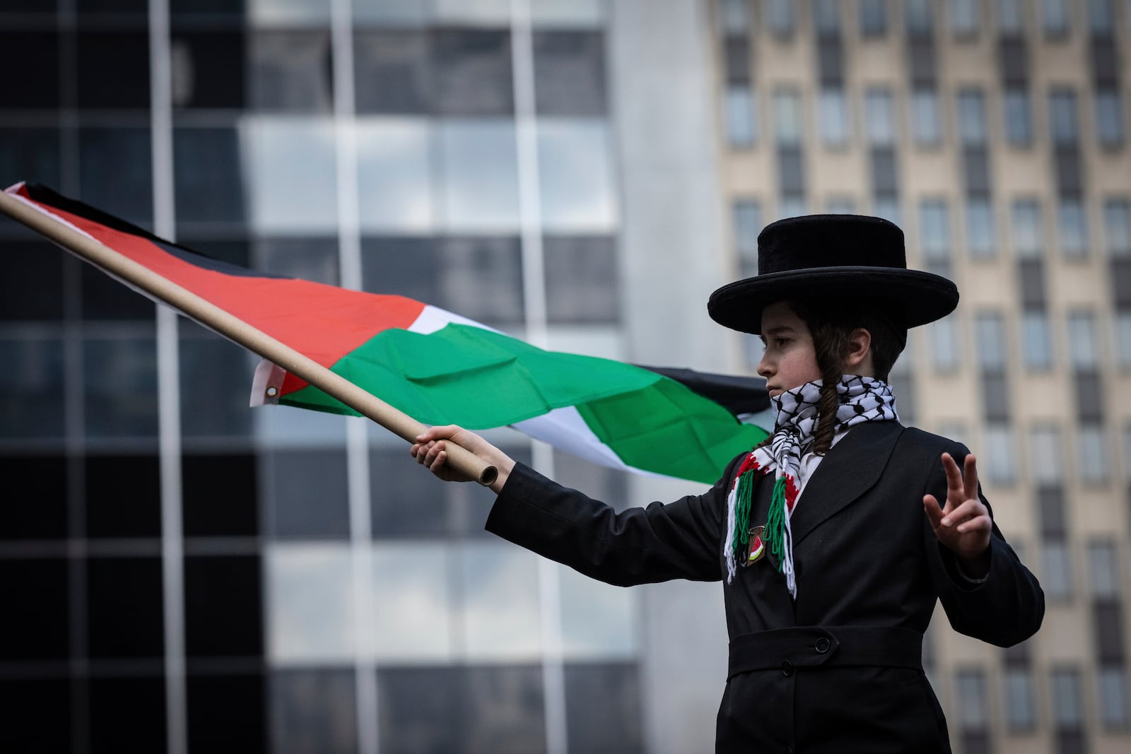 A young orthodox jewish boy waves a Palestinian flag in Foley Square, outside the Manhattan federal court, prior to the deportation case of Mahmoud Khalil, Wednesday, March 12, 2025, in New York. (AP Photo/Stefan Jeremiah)