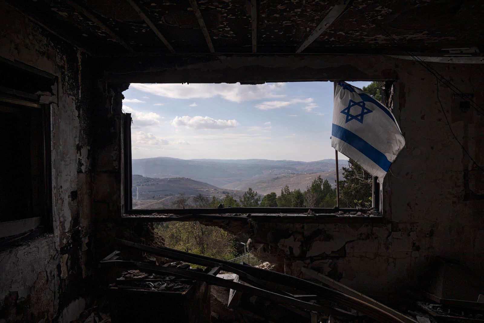 A Lebanese village is seen through a window of a damaged house that was hit by a rocket fired from Lebanon, in the Kibbutz Manara, located in the upper Galilee, northern Israel, Thursday, Nov. 28, 2024. (AP Photo/Leo Correa)