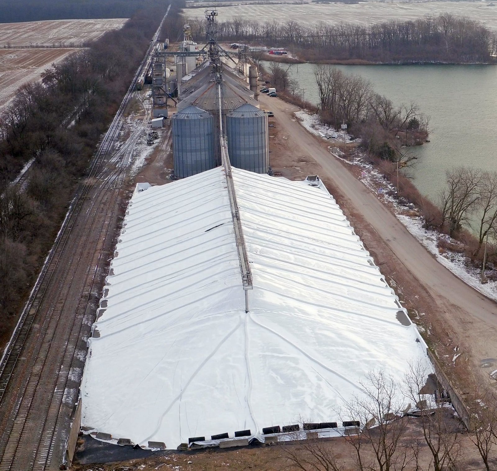 A 100,000-square-foot corn pen at Premier Grain in Wilmington is covered with plastic. More farmers turned to storing crop this year instead of selling it for low market prices. TY GREENLEES / STAFF