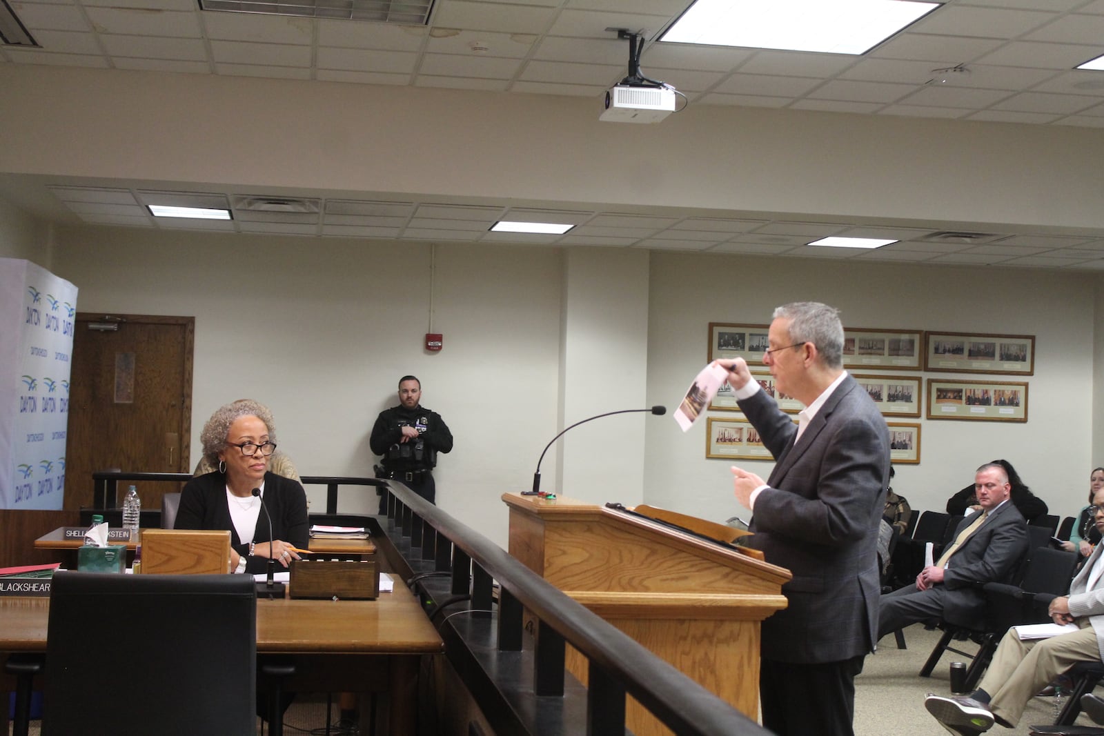 Robert Murphy, president of the Dayton Dragons, holds up a photo of what the area around Day Air Ballpark in downtown looked like before the baseball stadium was built. He spokes at a Dayton City Commission meeting. CORNELIUS FROLIK / STAFF