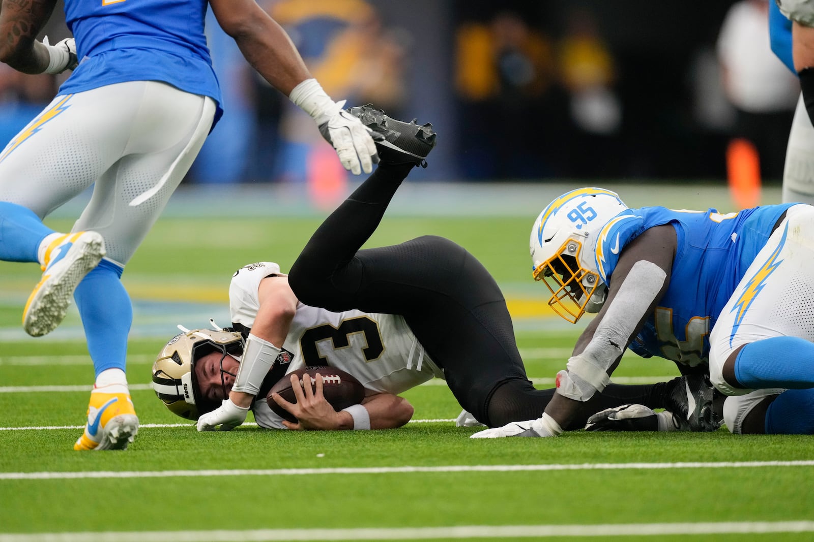 New Orleans Saints quarterback Jake Haener (3) is sacked by Los Angeles Chargers defensive tackle Poona Ford (95) in the second half of an NFL football game in Inglewood, Calif., Sunday, Oct. 27, 2024. (AP Photo/Mark J. Terrill)