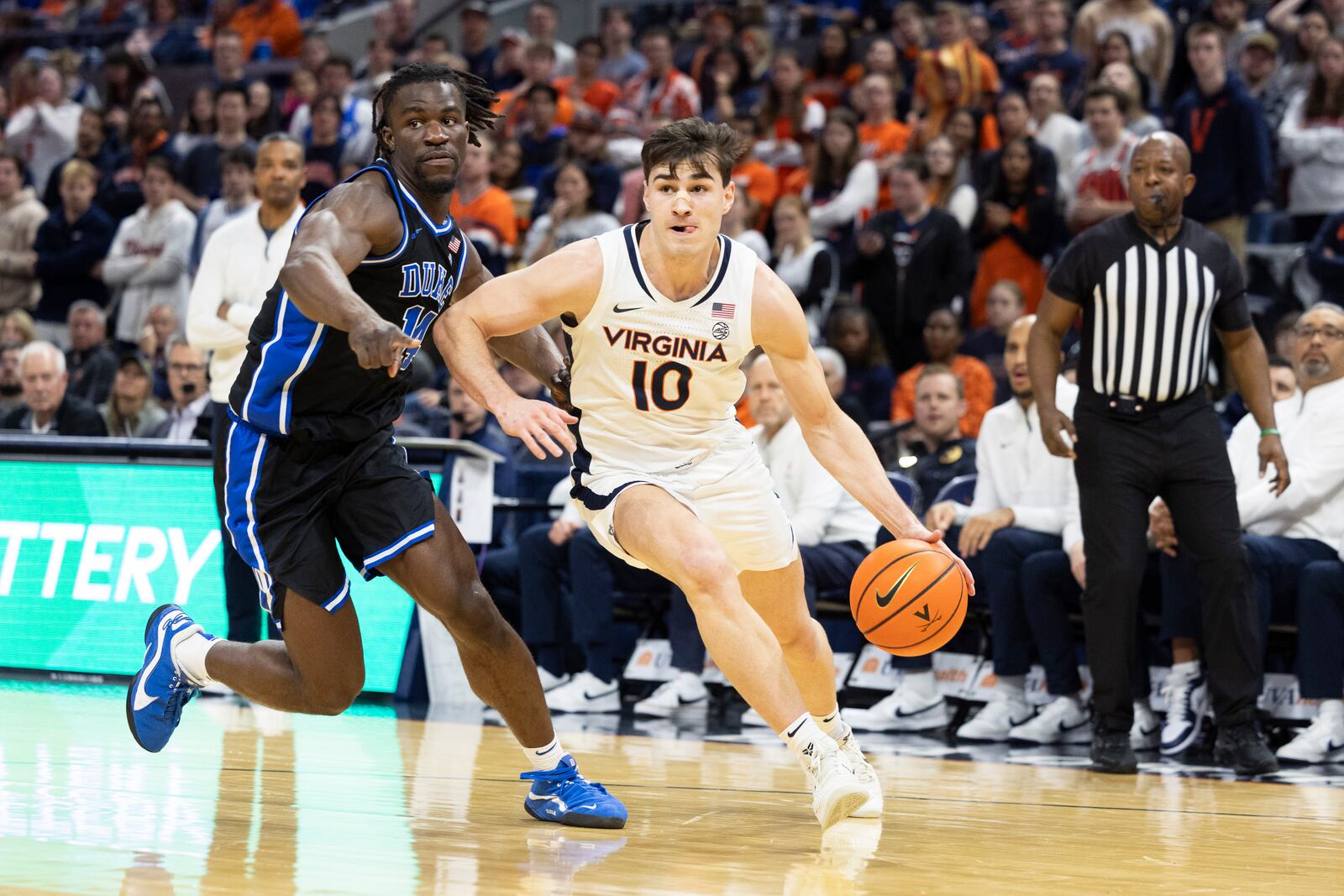 Virginia guard Taine Murray (10) defends the ball from Duke guard Sion James during the second half of an NCAA college basketball game, Monday, Feb. 17, 2025, in Charlottesville, Va. (AP Photo/Mike Kropf)