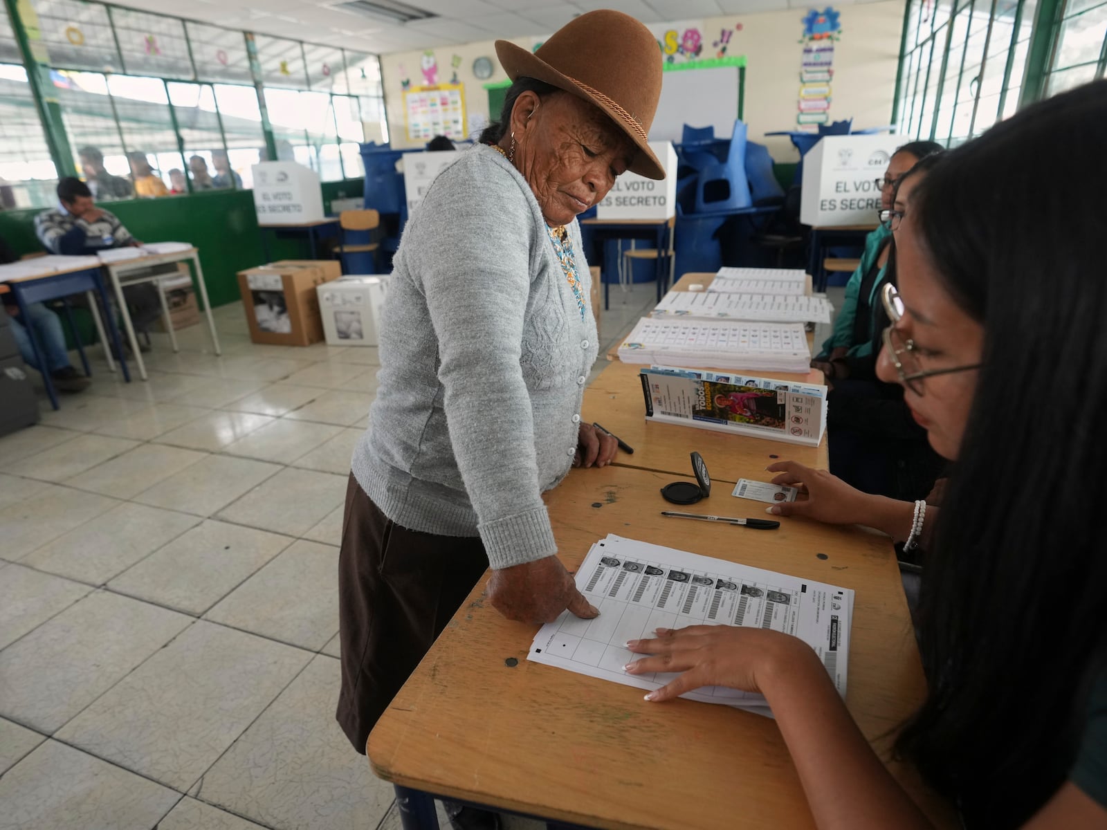 A woman stamps her fingerprint on the voter list during presidential elections in Quito, Ecuador, Sunday, Feb. 9, 2025. (AP Photo/Dolores Ochoa)