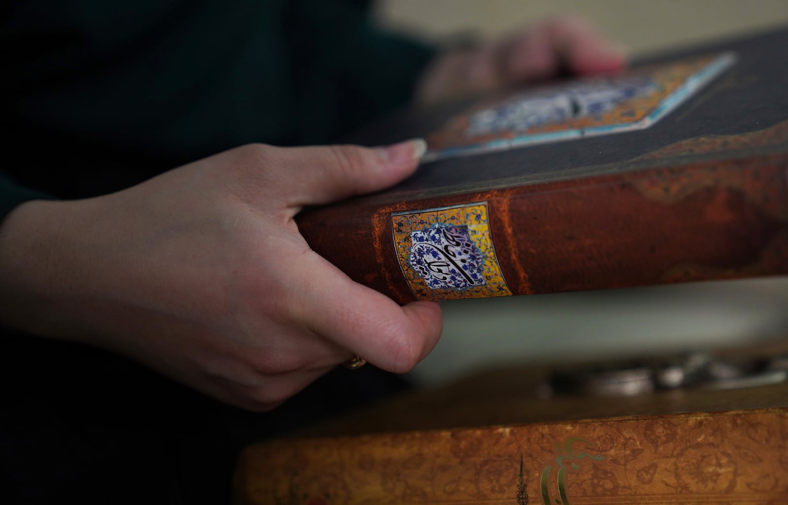 Marjila Badakhsh holds a book of poems she brought from Afghanistan when resettling in the United States in 2021, in Alexandria, Va., Wednesday, March 5, 2025. (AP Photo/Jessie Wardarski)