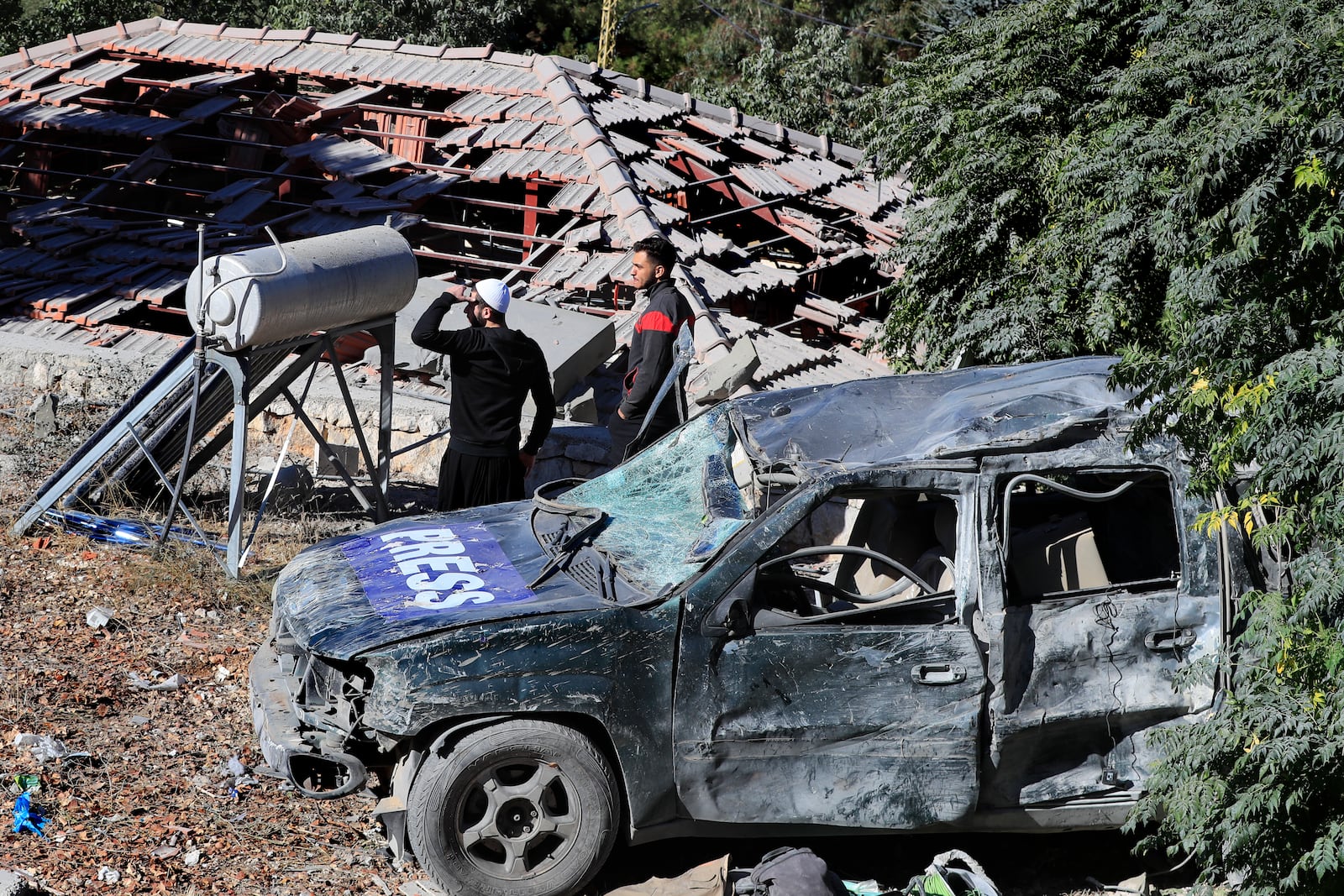 People observe the site where an Israeli airstrike hit a compound housing journalists, killing three media staffers from two different news agencies according to Lebanon's state-run National News Agency, in Hasbaya village, southeast Lebanon, Friday, Oct. 25, 2024. (AP Photo/Mohammed Zaatari)