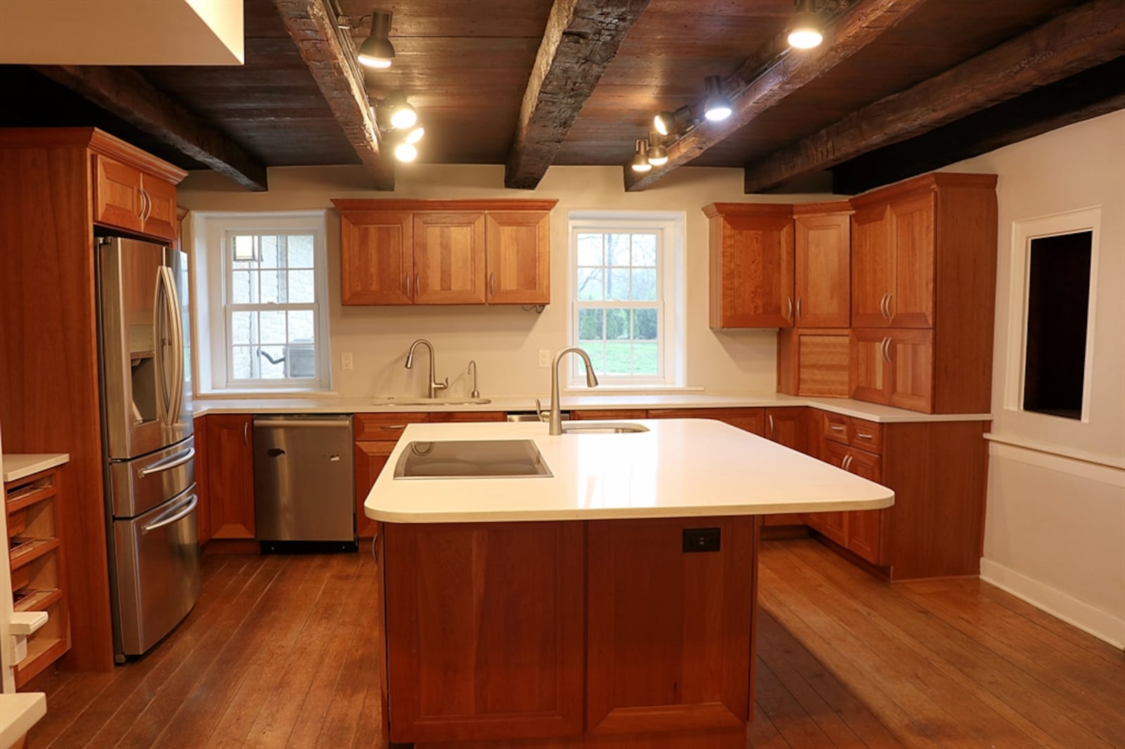 In the kitchen, cherry cabinetry fills nearly every wall with complementary quartz counters. 