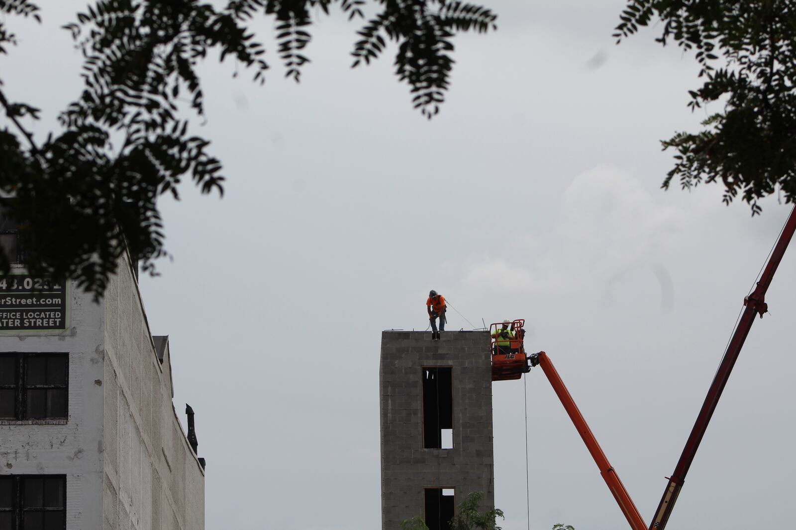 A construction worker stands atop a shaft on the site of the new Sutton apartments, located just east of Day Air Ballpark, where the Dayton Dragons play. CORNELIUS FROLIK / STAFF