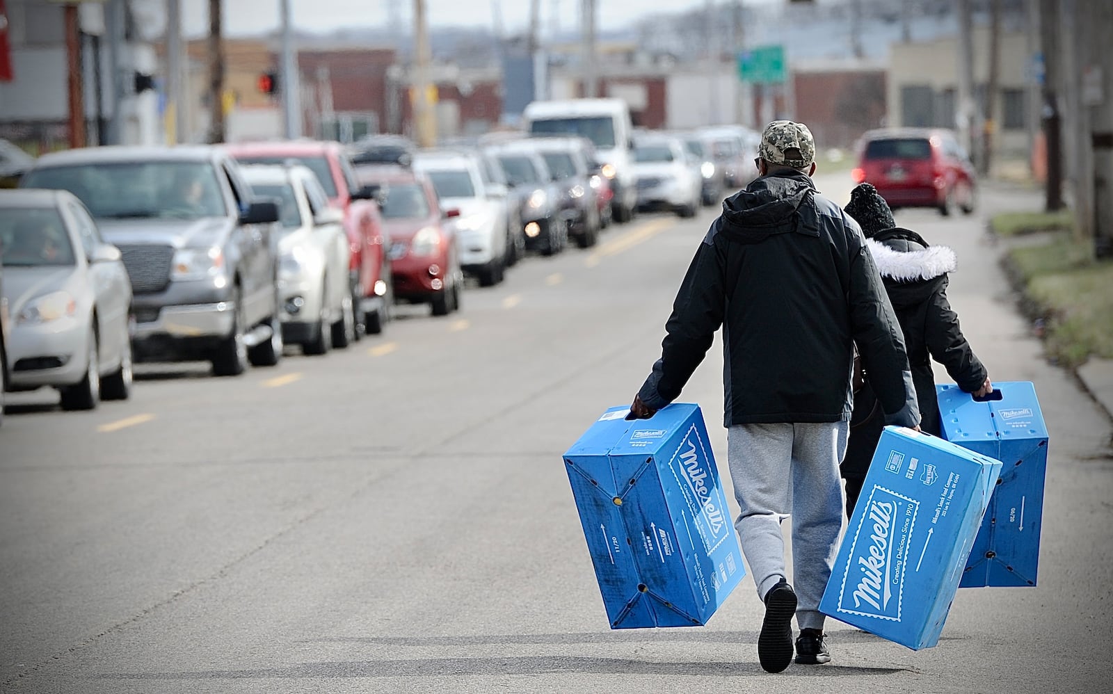 Bobby and Carolyn Allen carry their cases of Mikesells potato chips down Stanley Avenue to the car that they parked down the block Thursday march 2, 2023. MARSHALL GORBY \STAFF