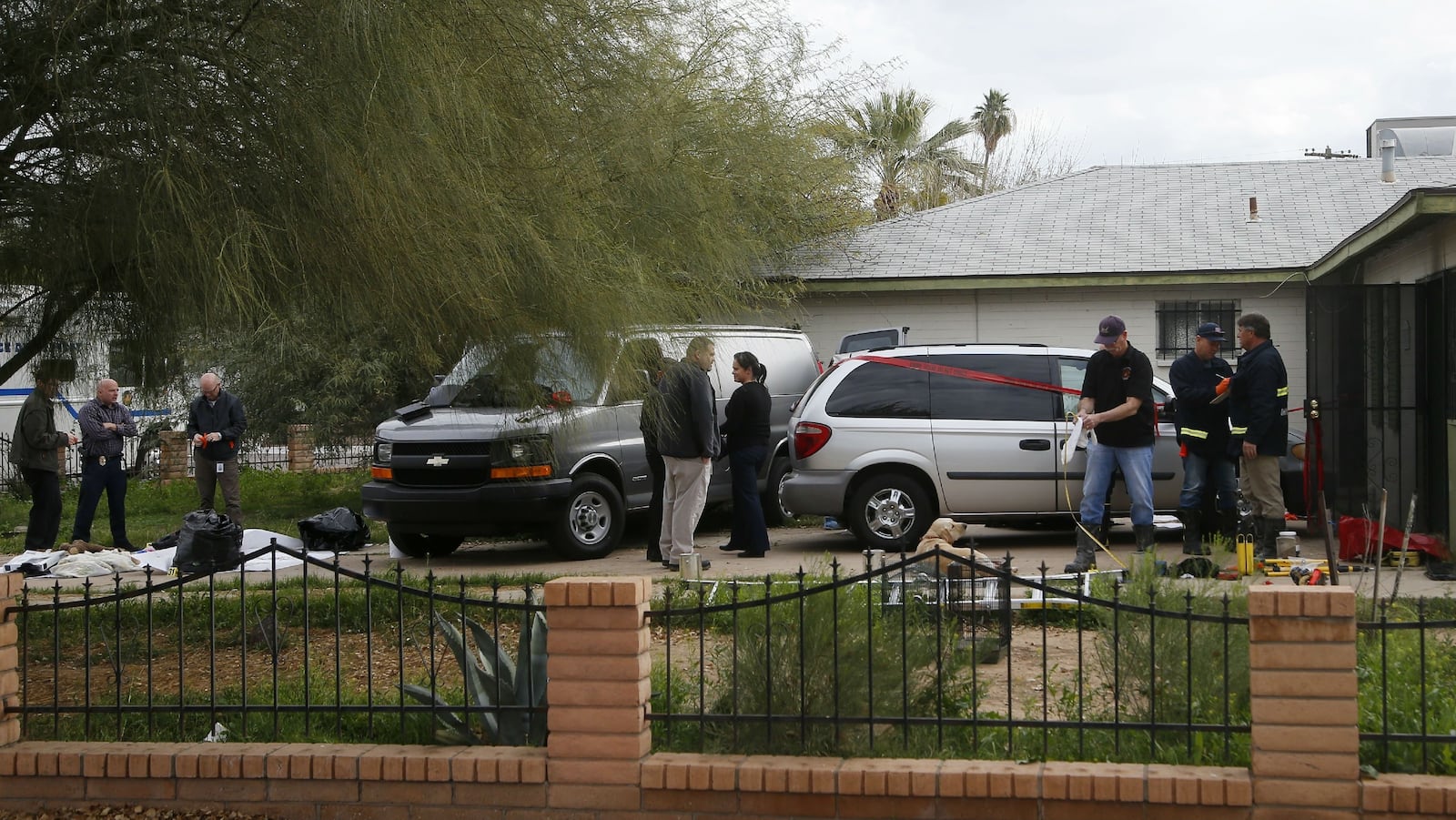 Phoenix fire and police investigators work Wednesday, Jan. 29, 2020, outside the home of Rafael and Maribel Loera. The couple are charged with concealing their dead 11-year-old daughter’s body in their attic for more than two years and abusing their surviving children.