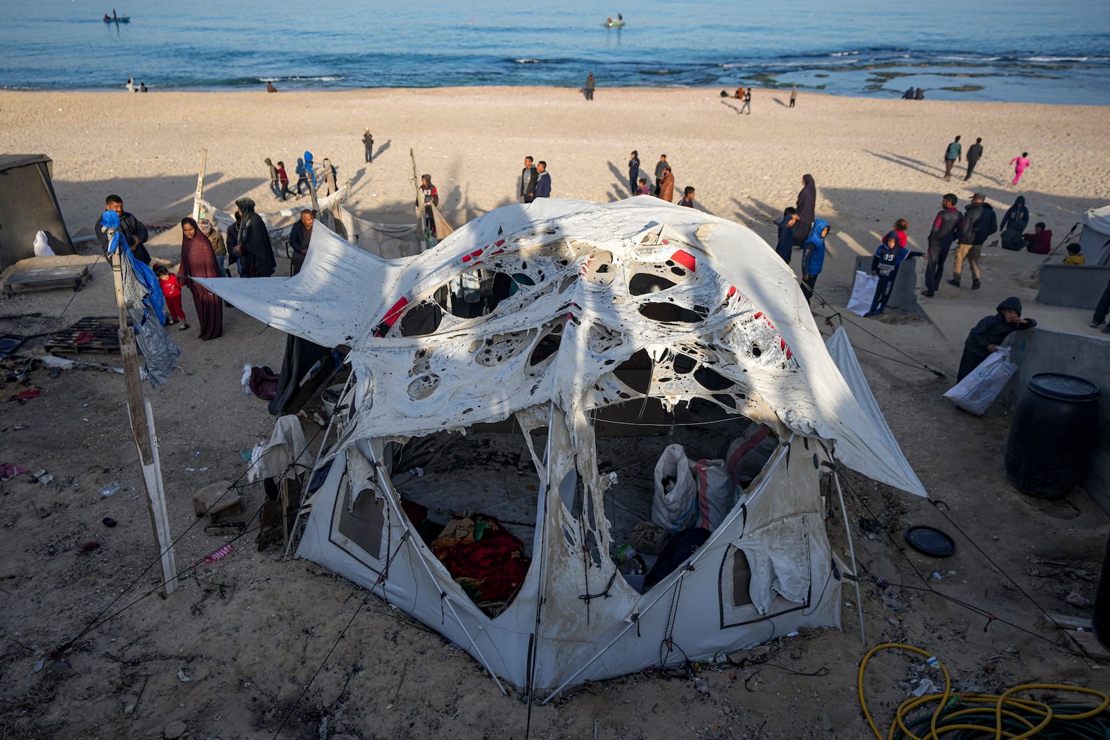 Palestinians inspect the site of an Israeli army strike early Tuesday morning in Deir Al-Balah in the central Gaza Strip, Tuesday, Jan. 14, 2025. (AP Photo/Abdel Kareem Hana)