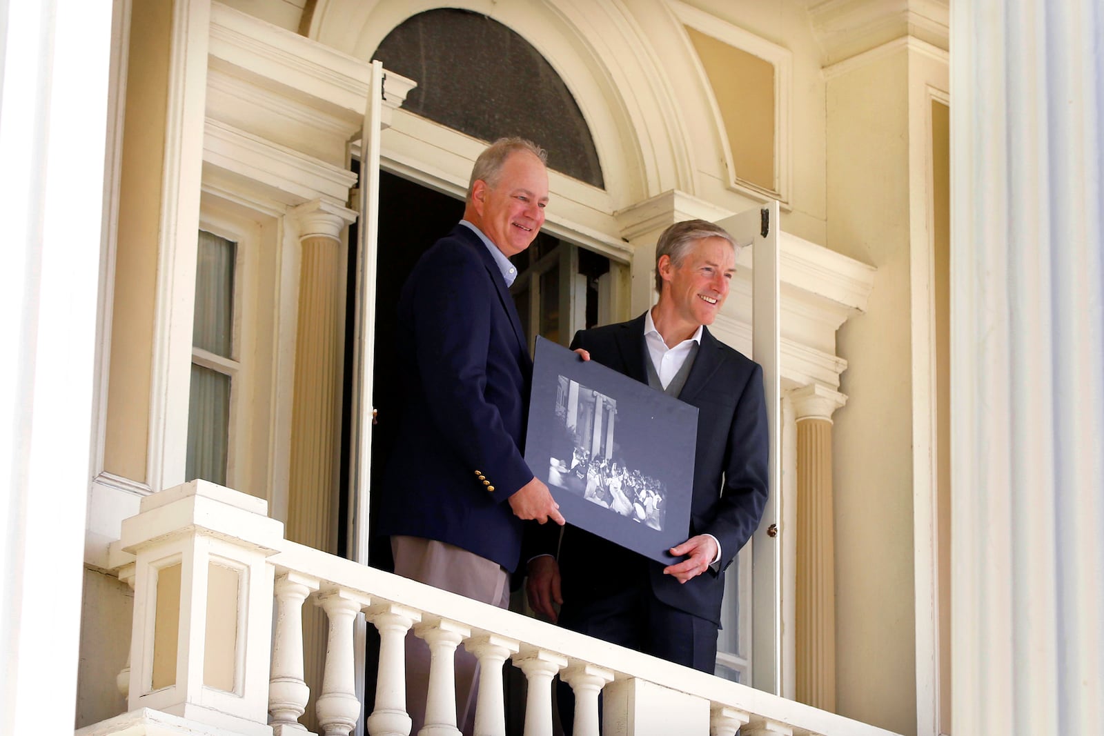 Stephen Wright, great-grandnephew of the Wright Brothers, (left) and Erik Lindbergh, grandson of famed aviator Charles Lindbergh, pose together in 2017on the balcony of Hawthorn Hill, Orville Wright's Oakwood mansion. In 1927 Charles Lindbergh visited Orville Wright at the home a month after his record-setting solo flight from New York to Paris. A crowd gathered on the lawn and Lindbergh stepped briefly onto the balcony to greet them. The men are holding a photograph of the historic moment.  LISA POWELL / STAFF