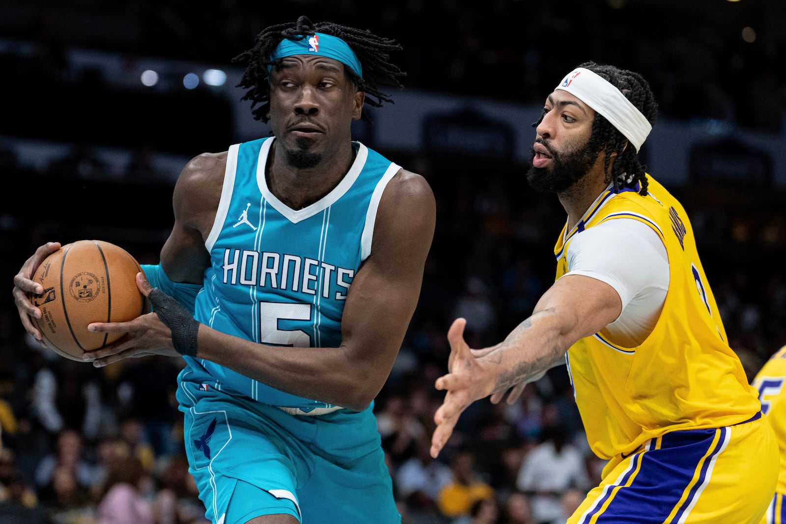 Los Angeles Lakers forward Anthony Davis, right, guards against Charlotte Hornets center Mark Williams, left, during the second half of an NBA basketball game Monday, Jan. 27, 2025, in Charlotte, N.C. (AP Photo/Jacob Kupferman)