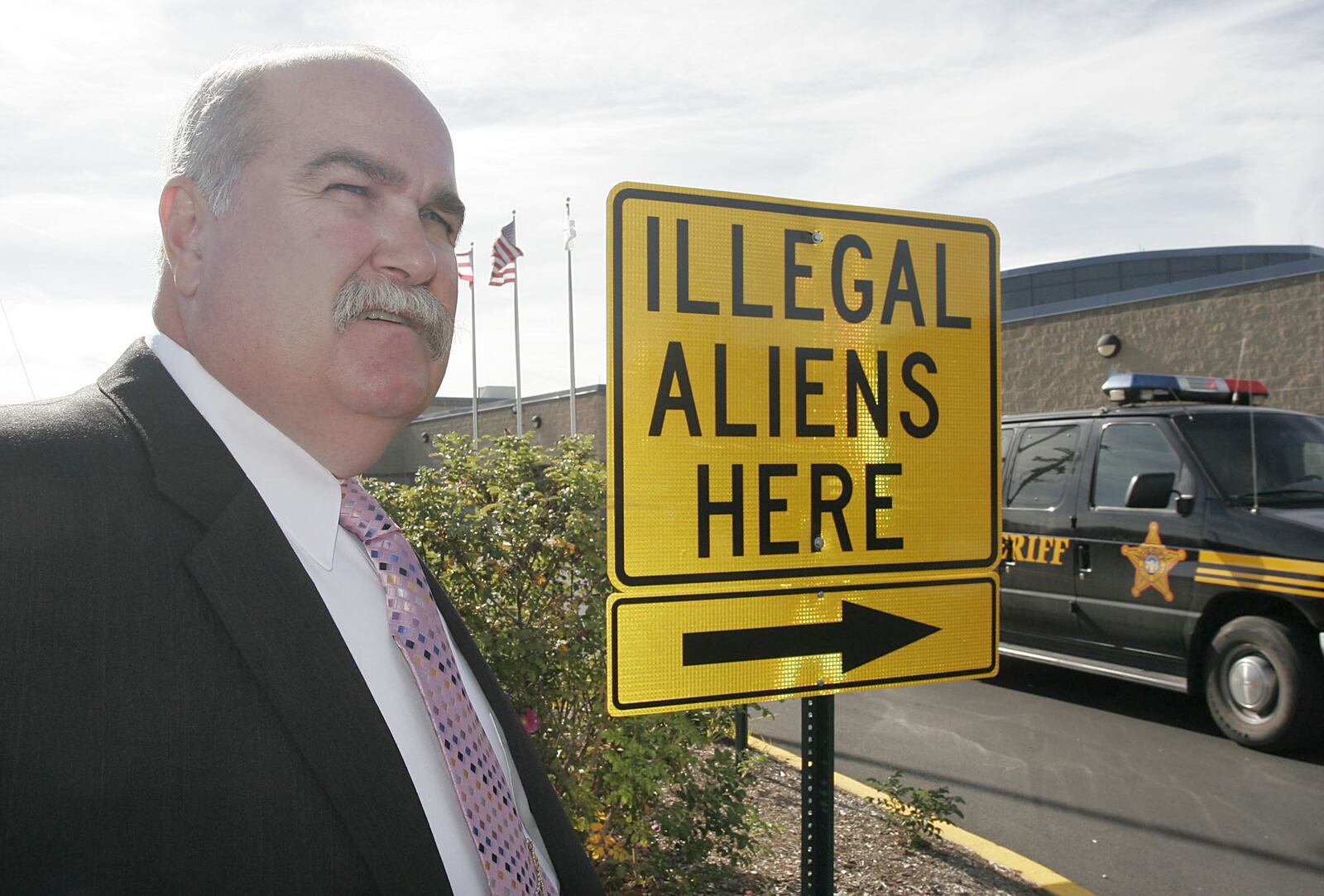 Butler County Sheriff Richard Jones stands next to a illegal aliens sign he had placed in the parking lot of the Butler County Sheriff’s Department, Thursday, Nov. 3, 2005 in Hamilton, Ohio. Jones says federal authorities aren’t doing enough to enforce immigration laws.