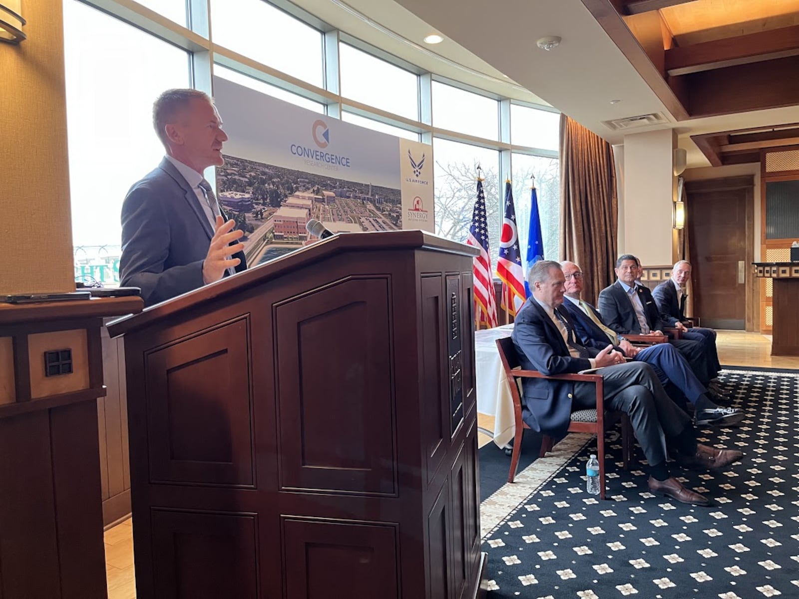 Jerad Barnett, president and CEO of Synergy and Mills Development, at the podium in Monday's announcement of the Convergence Research Center. THOMAS GNAU/STAFF