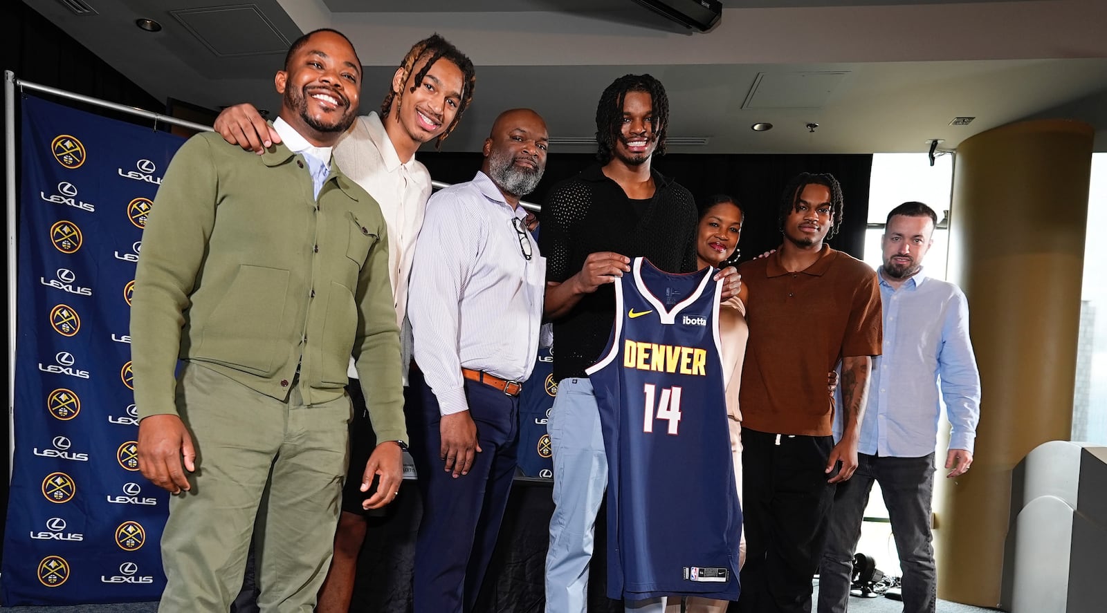 Denver Nuggets 2024 first-round draft pick DaRon Holmes II, center, holds up his jersey for a photograph with, from left, business manager Mitch Brown, brother Cameron Holmes, father DaRon, Sr., mother Tomika, brother Quintyn and agent Aaron Reilly during an NBA basketball news conference Monday, July 1, 2024, in Denver. (AP Photo/David Zalubowski)