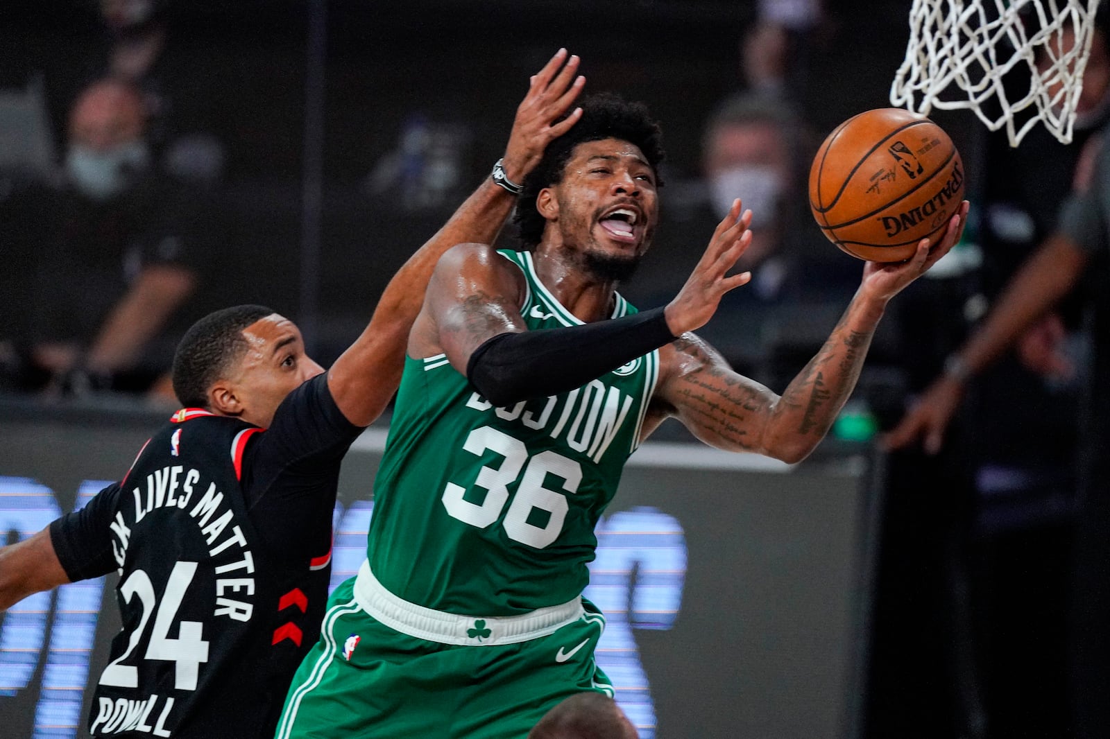 Boston Celtics guard Marcus Smart (36) shoots in front of Toronto Raptors guard Norman Powell (24) during the second half of an NBA conference semifinal playoff basketball game Wednesday, Sept. 9, 2020, in Lake Buena Vista, Fla. (AP Photo/Mark J. Terrill)