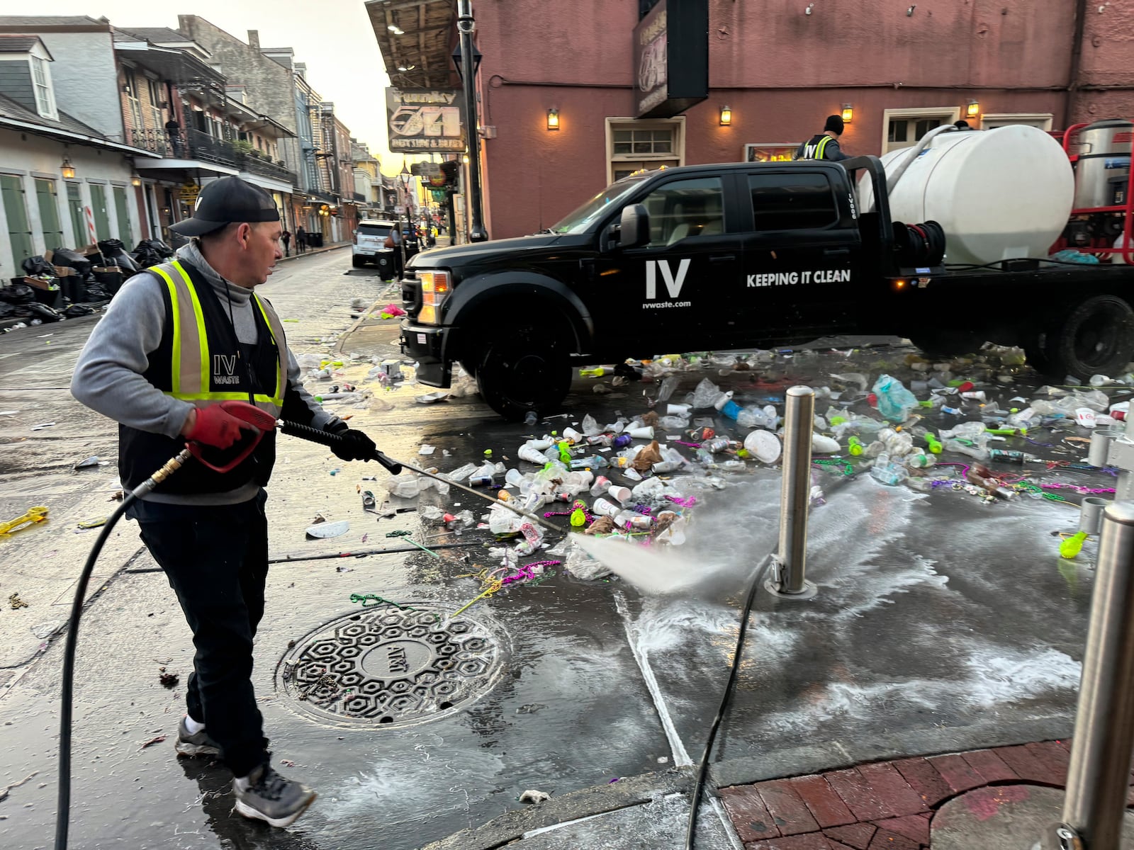 An employee of IV Waste, the company tasked with cleaning up New Orleans' French Quarter, pressure washes a street on Ash Wednesday, March 5, 2025, the day after Mardi Gras. (AP Photo/Jack Brook)