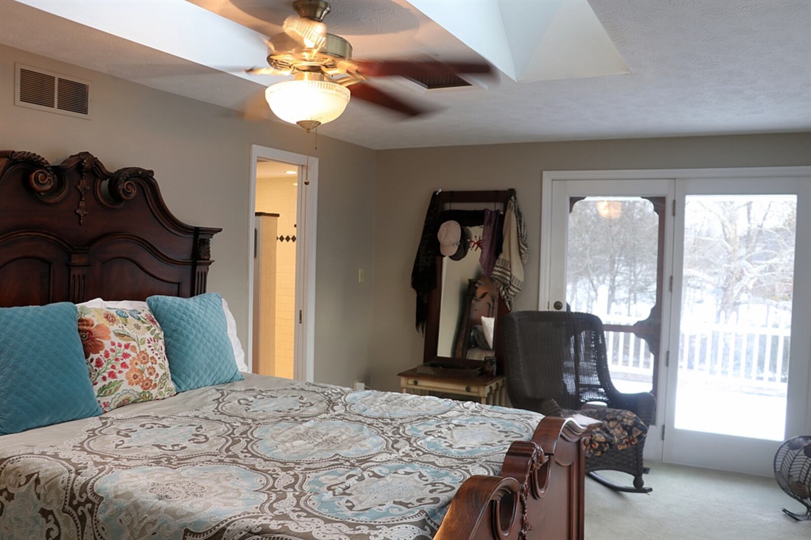 The main bedroom has a separate sitting room with a wall of built-in shelves that surround a window and a closet. The bedroom has two skylights and access to the outside balcony. 