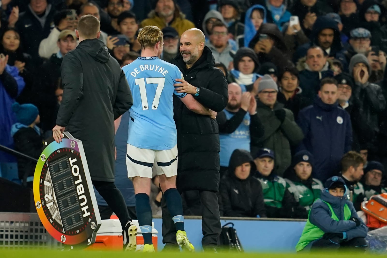 Manchester City's head coach Pep Guardiola, right, greets Kevin De Bruyne during a substitution at the English Premier League soccer match between Manchester City and Nottingham Forest at the Etihad Stadium in Manchester, Wednesday, Dec. 4, 2024. (AP Photo/Dave Thompson)