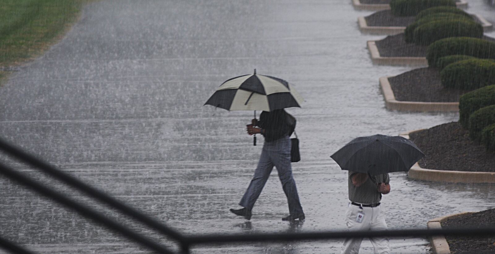 The umbrellas were out around the University of Dayton campus as heavy rain moved into the Miami Valley. (Marshall Gorby/Staff)