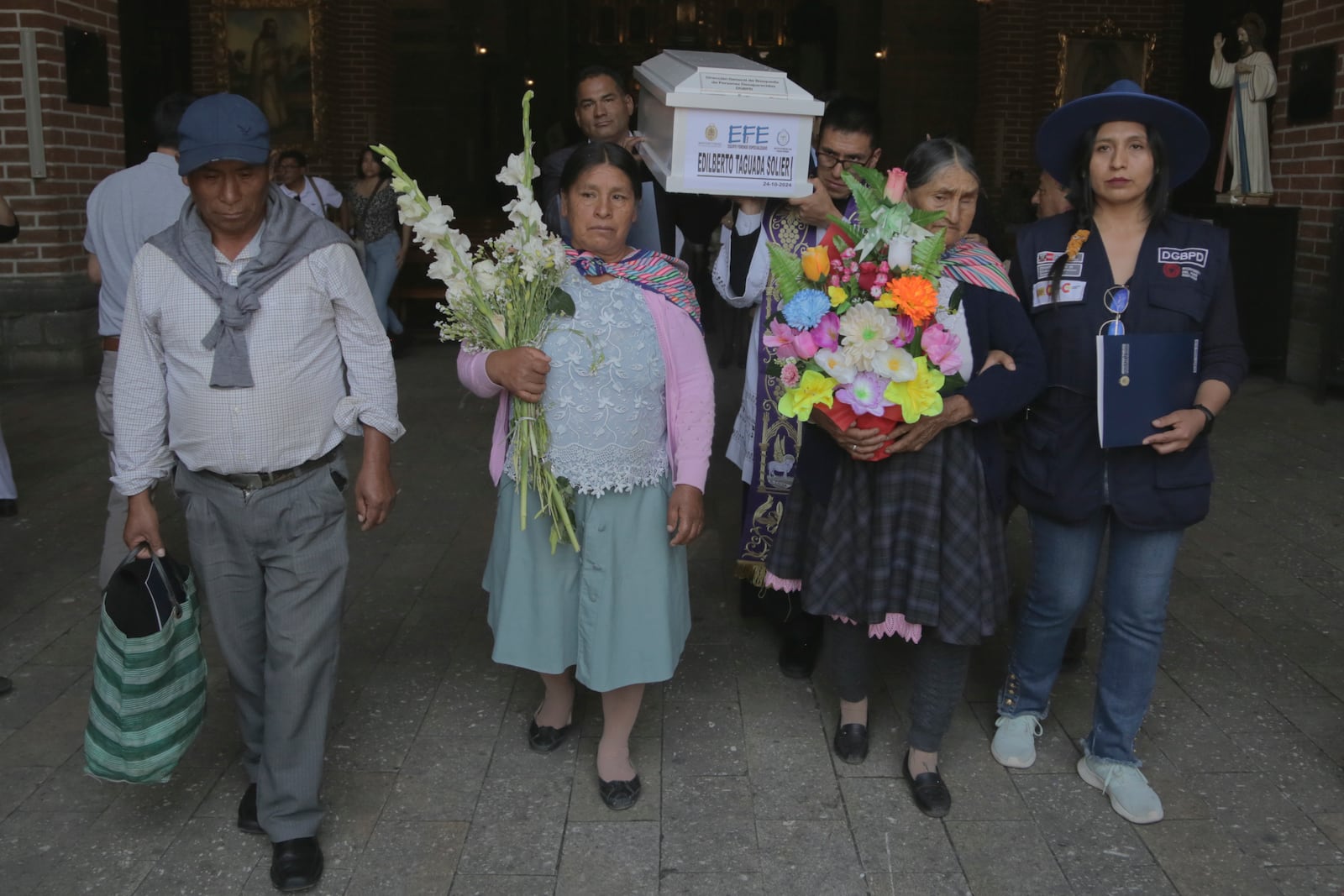 People carry the remains of relatives who were killed during Peru's internal armed conflict (1980-2000) to a cemetery during a wake in Ayacucho, Peru, Wednesday, Oct. 23, 2024, the day the remains were returned to families. (AP Photo/Silvio La Rosa)