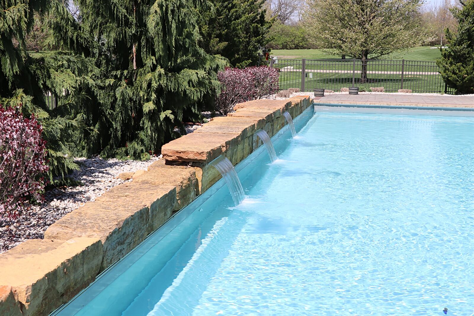 The salt-water, in-ground swimming pool features 3 waterfalls, and the backyard is fenced. CONTRIBUTED PHOTO BY KATHY TYLER