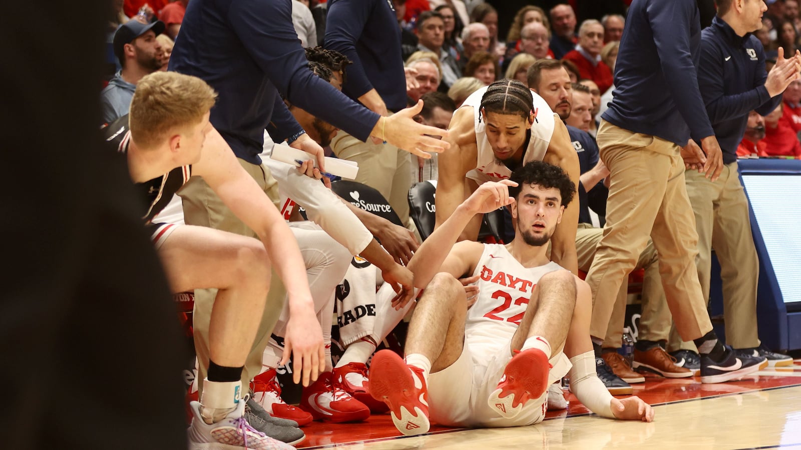 Dayton's Mustapha Amzil falls into the bench after getting fouled on a 3-point attempt against Davidson on Tuesday, Jan. 17, 2023, at UD Arena. David Jablonski/Staff