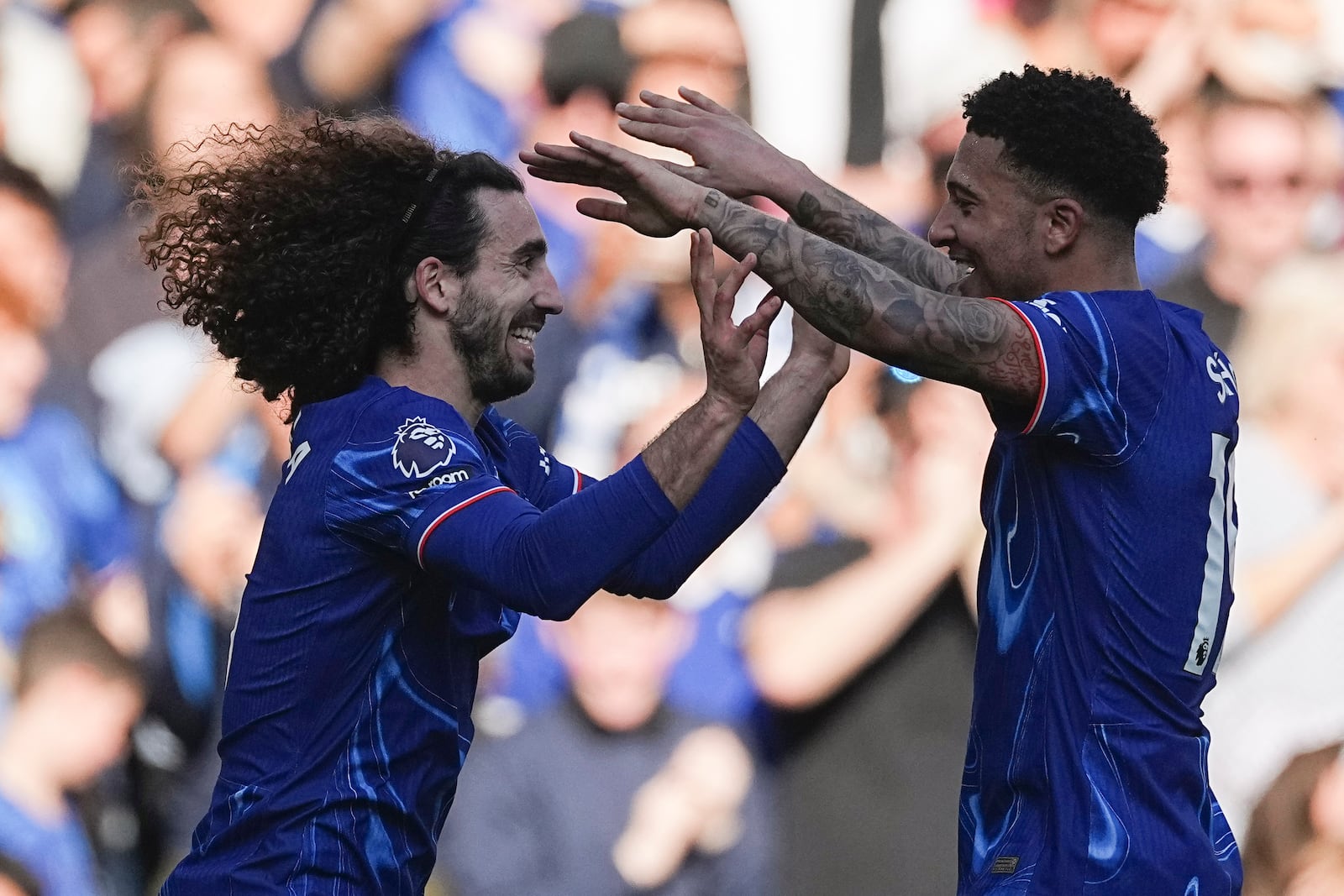 Chelsea's Marc Cucurella, left, celebrates with his teammate Jadon Sancho after scoring his side's first goal during the English Premier League soccer match between Chelsea and Leicester City, at the Stamford Bridge stadium in London, Sunday, March 9, 2025. (AP Photo/Dave Shopland)