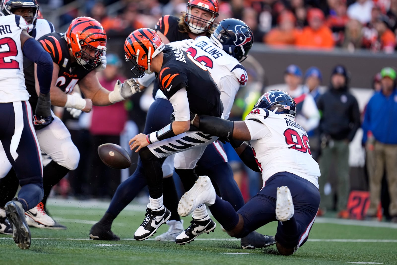 Cincinnati Bengals quarterback Joe Burrow, center, fumbles the ball as he is hit by Houston Texans defensive tackle Sheldon Rankins (98) during the second half of an NFL football game Sunday, Nov. 12, 2023, in Cincinnati. The Bengals recovered the fumble. (AP Photo/Michael Conroy)