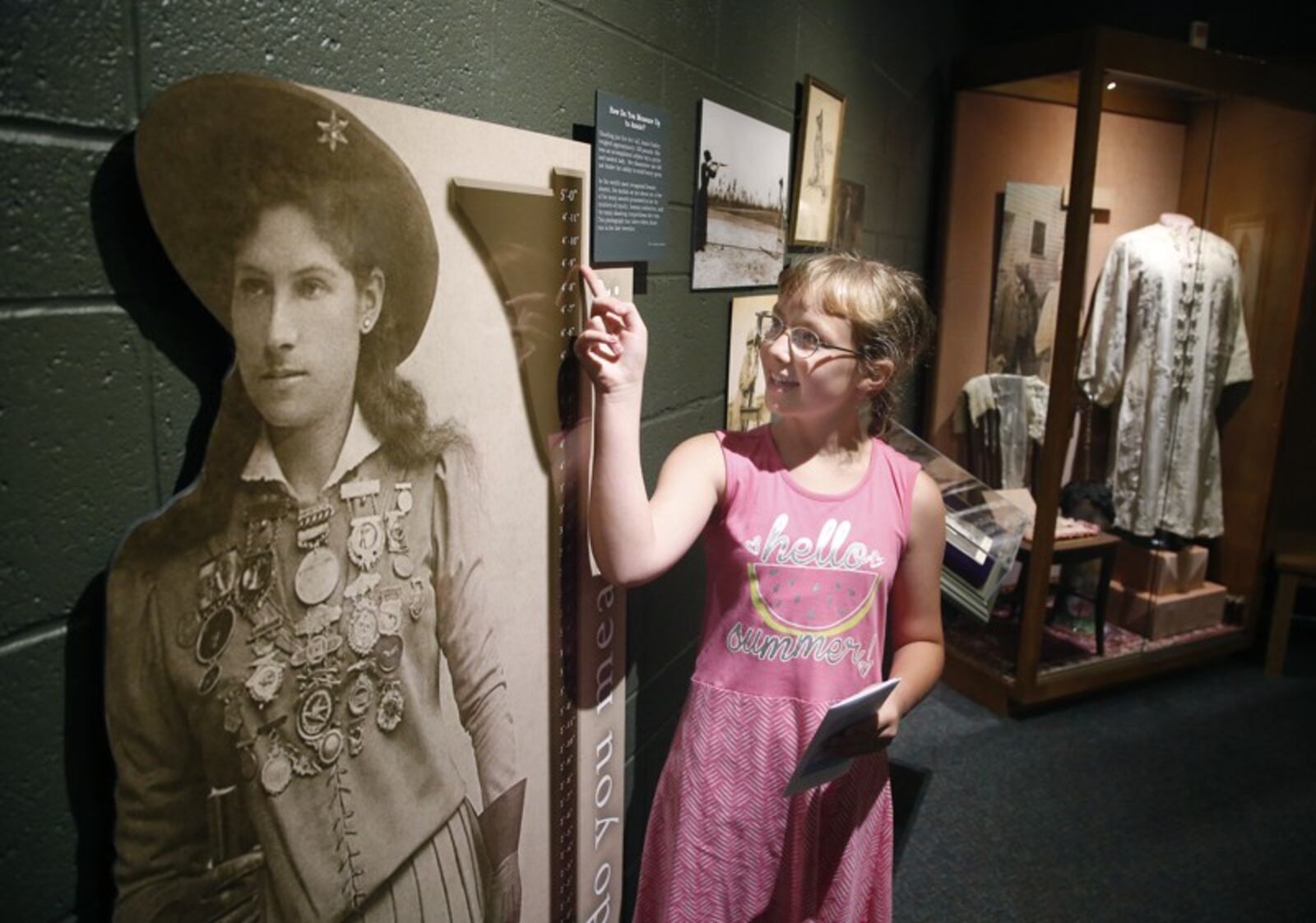 Alexis Stump of Union City, Indiana, compares her own height to a life-sized cutout of Annie Oakley at The Annie Oakley Center in Greenville, Ohio. The museum will offer free admission Saturday for Museum Day.