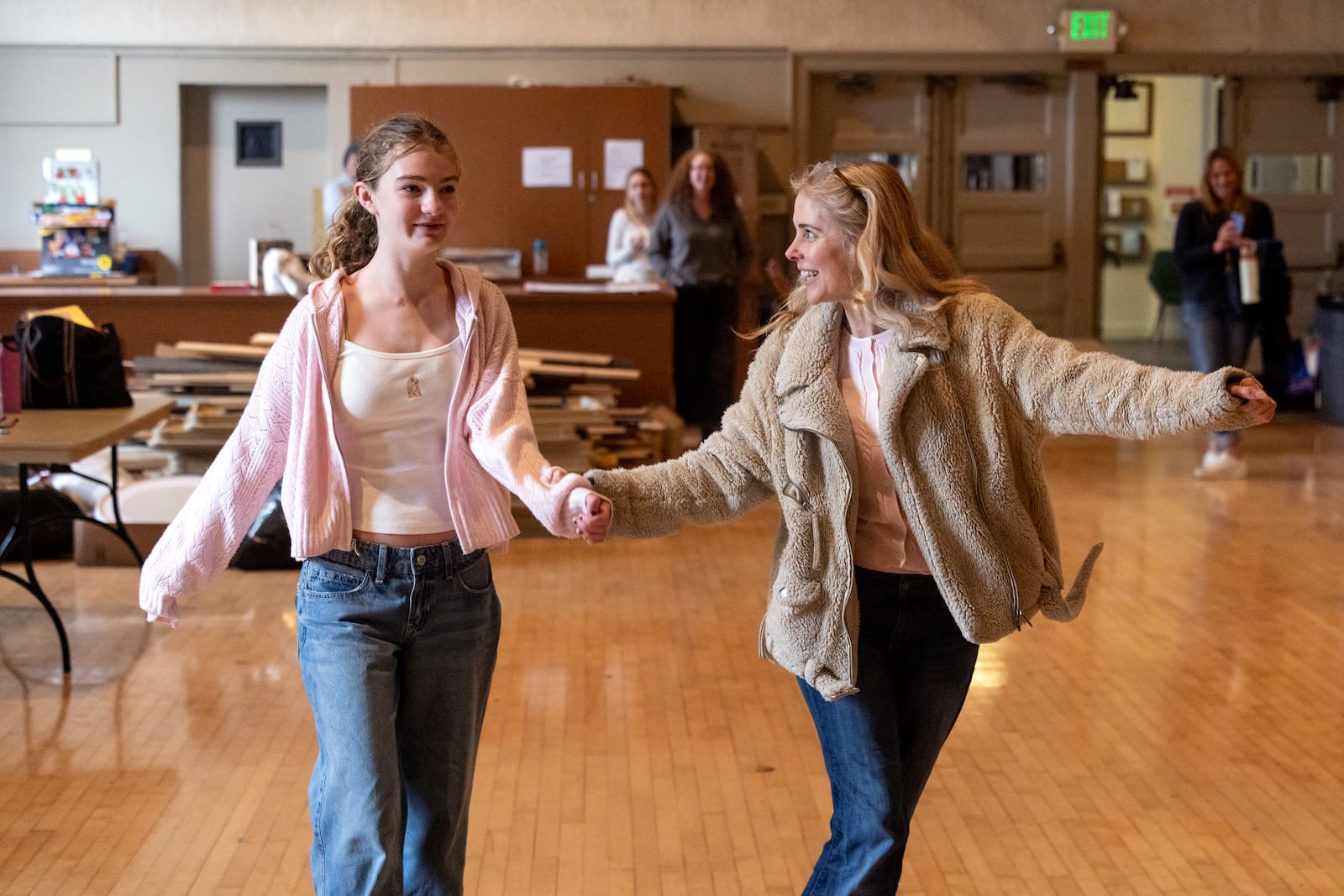 A student, left, with the Theatre Palisades' youth theatre program interacts with American actress and singer Kerry Butler during a master class after their theater was destroyed by the Palisades Fire, at the Saint Monica Preparatory's auditorium in Santa Monica, Calif., Sunday, Jan. 26, 2025. (AP Photo/Etienne Laurent)