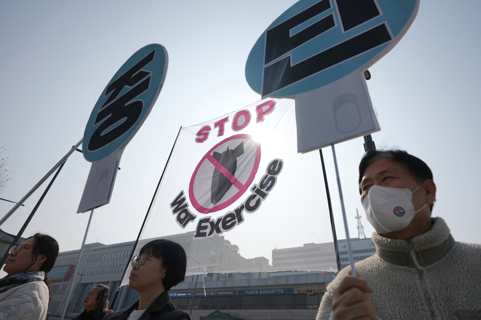 Protesters hold signs during a press conference demanding to stop the upcoming Freedom Shield military exercise between the U.S. and South Korea, near the Defense Ministry in Seoul, South Korea, Monday, March 10, 2025. The letters read "Stop." (AP Photo/Lee Jin-man)