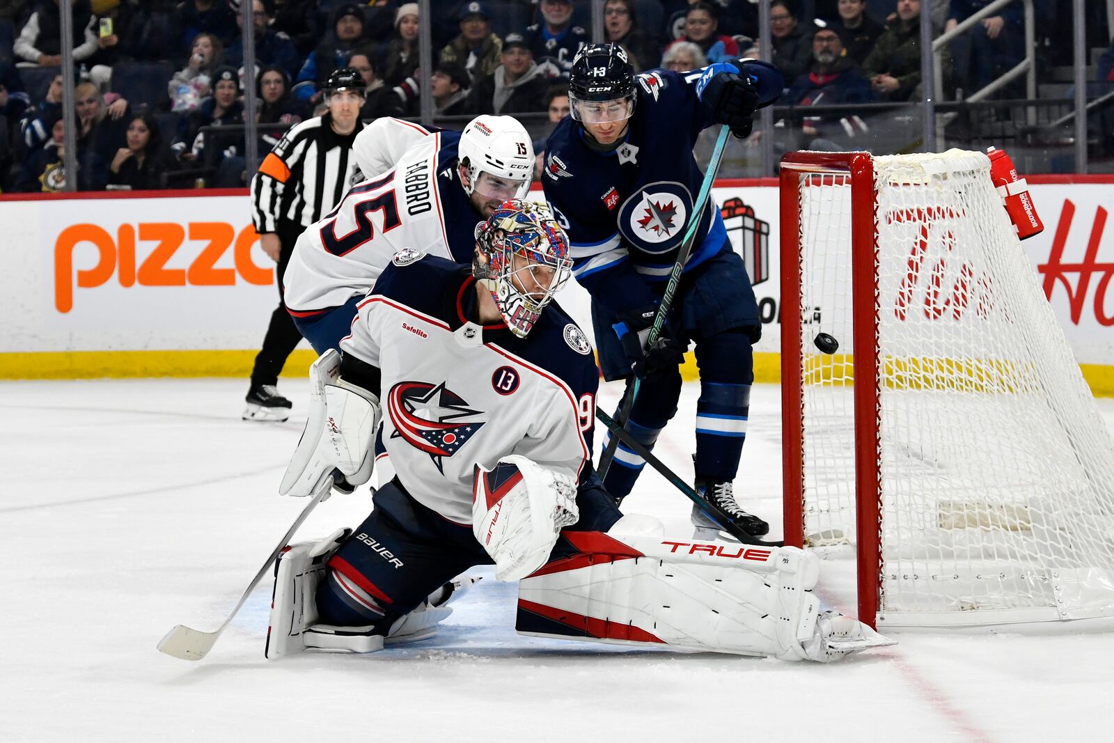 A shot by Winnipeg Jets' Kyle Connor, not shown, gets past Columbus Blue Jackets' goaltender Elvis Merzlikins (90) for a goal during the second period of an NHL hockey game in Winnipeg, Canada Sunday, Dec. 8, 2024. (Fred Greenslade/The Canadian Press via AP)