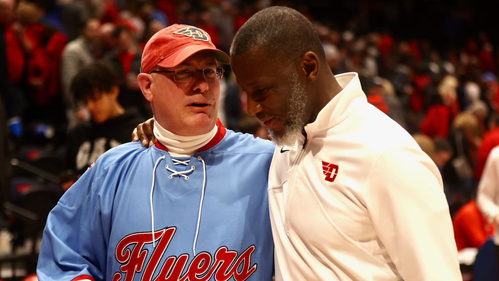 University of Dayton President Eric Spina leaves the court with coach Anthony Grant after a victory against Saint Louis on Friday, Feb. 10, 2023, at UD Arena. David Jablonski/Staff