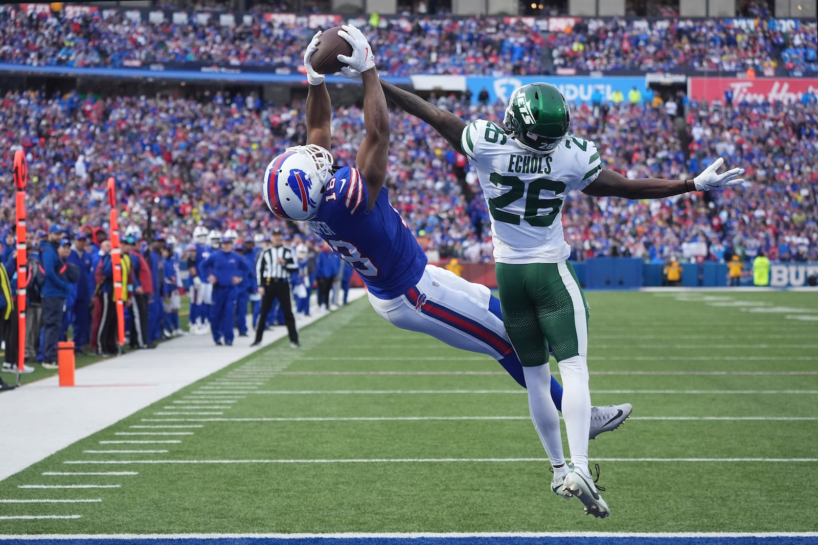 Buffalo Bills wide receiver Amari Cooper (18) catches a pass for a touchdown in front of New York Jets cornerback Brandin Echols (26) during the second half of an NFL football game, Sunday, Dec. 29, 2024, in Orchard Park, N.Y. (AP Photo/Gene J. Puskar)