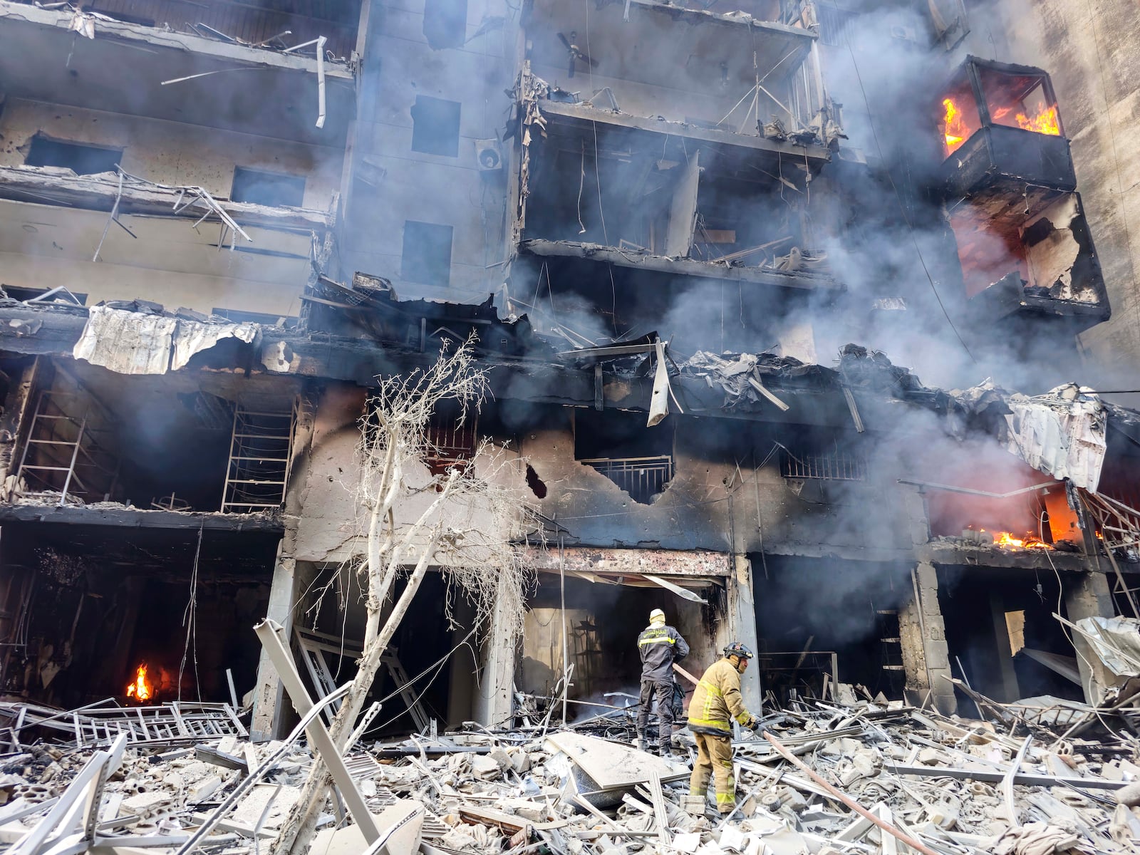 Civil defense workers extinguish a fire as smoke rises from the site of an Israeli airstrike in Dahiyeh, Beirut, Lebanon, Saturday, Nov. 9, 2024. (AP Photo/Hassan Ammar)