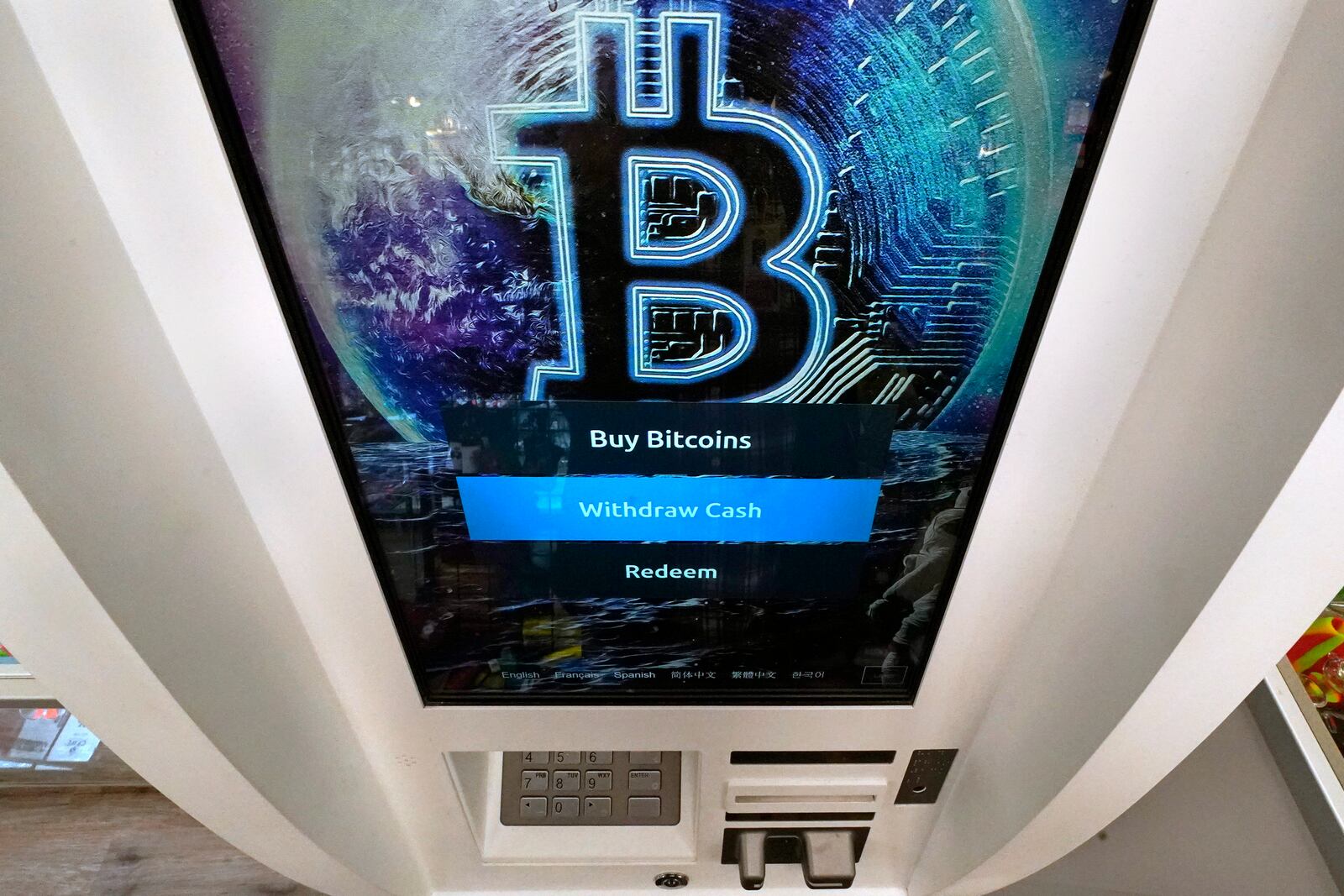 FILE - The Bitcoin logo appears on the display screen of a cryptocurrency ATM in Salem, N.H., Feb. 9, 2021. (AP Photo/Charles Krupa, File)