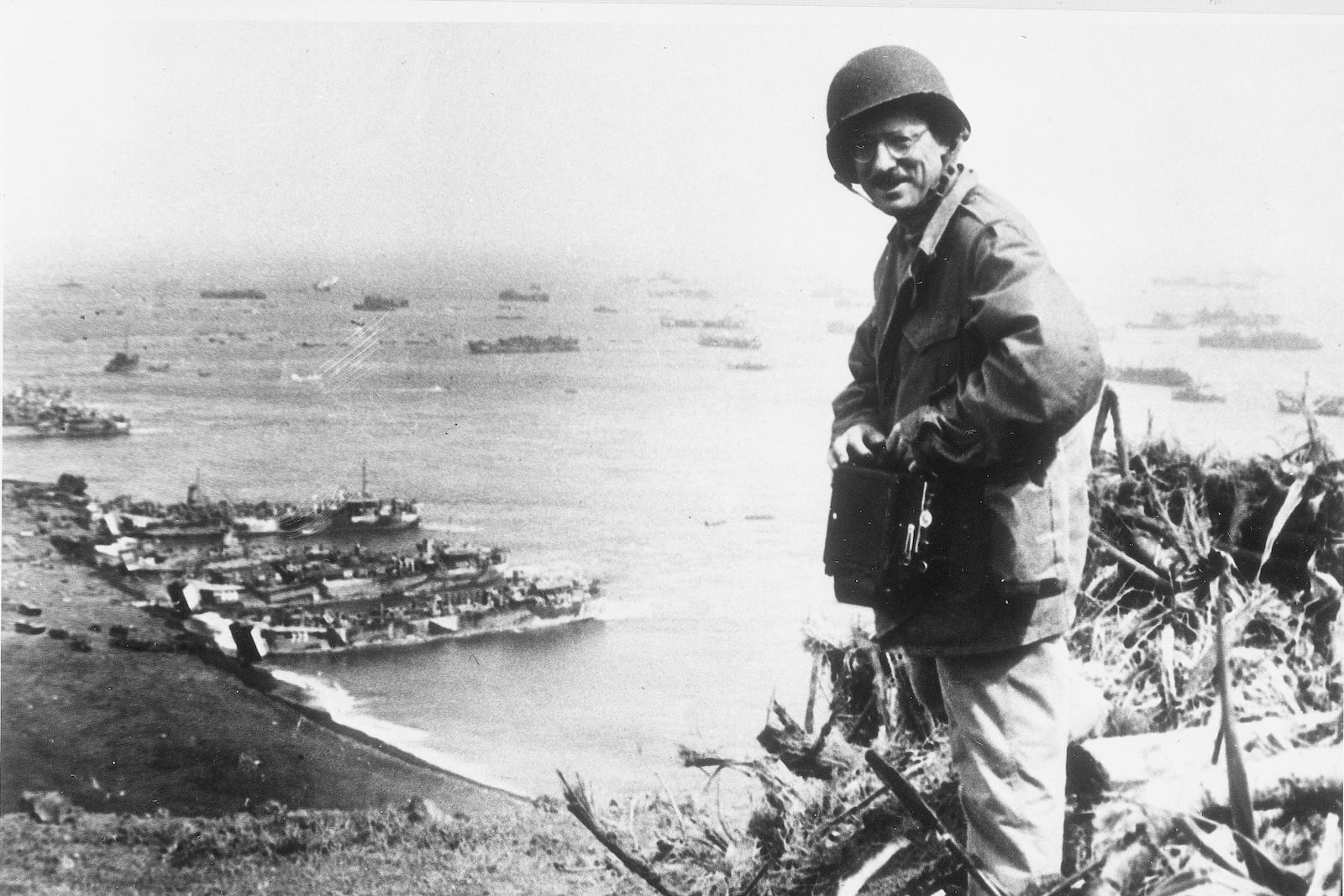 FILE - Joe Rosenthal, an Associated Press photographer, is shown with his camera equipment looking over Iwo Jima, Japanese volcano island during World War II, March,1945. (U.S. Marine Corps via AP, File)