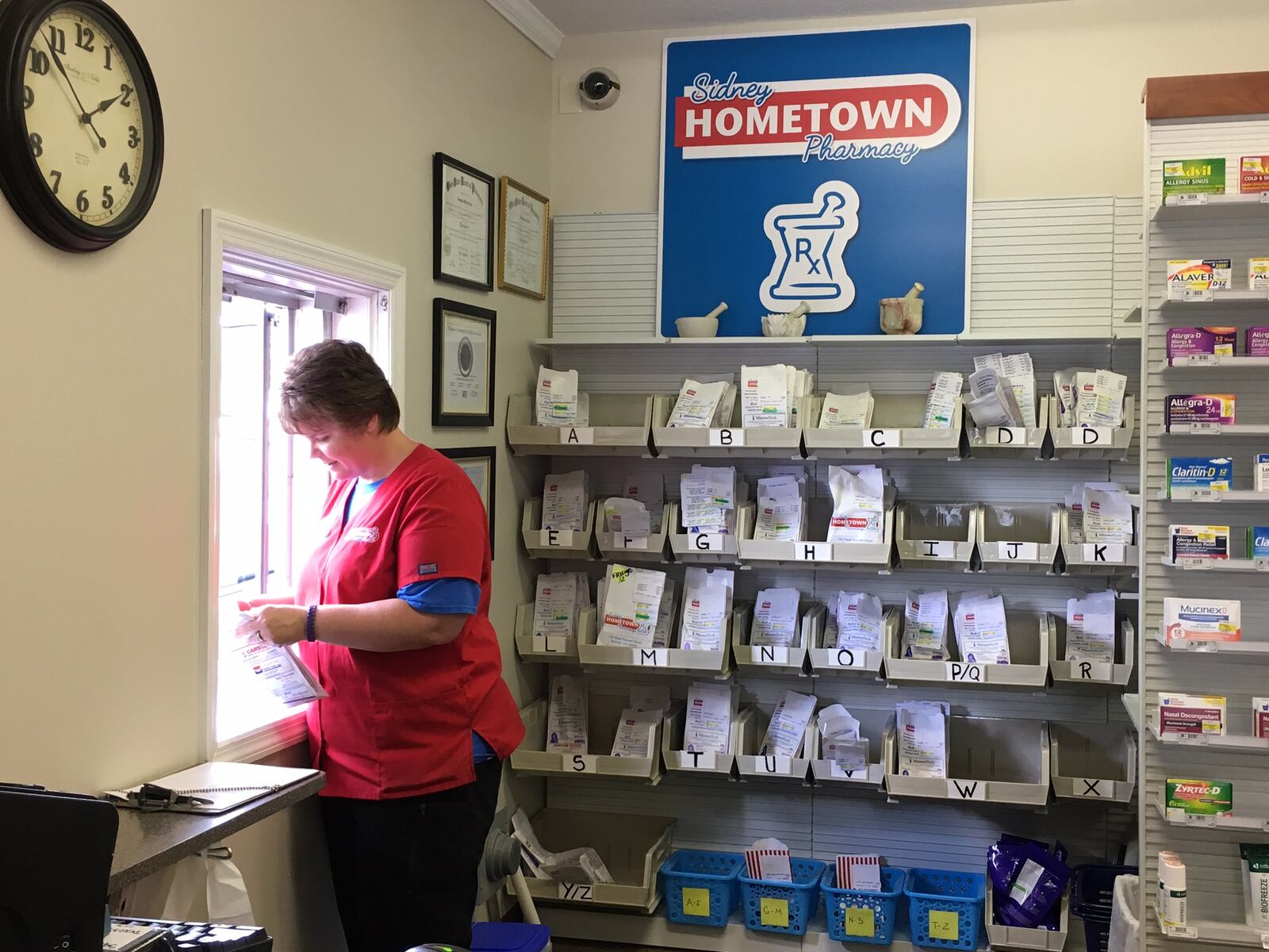 An employee helps a drive-thru customer at Sidney Hometown Pharmacy.