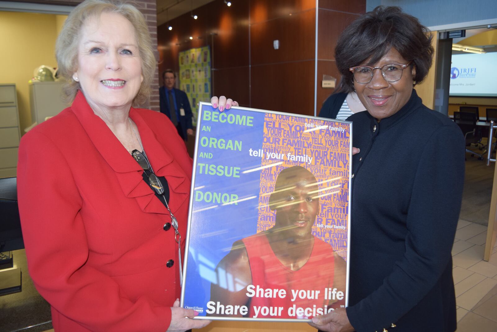 Community Blood Center COO Diane Wilson and philanthropist Deloris Jordan hold an organ and tissue donation poster featuring Deloris' son, basketball great Michael Jordan, during a visit to the Center for Tissue Innovation and Research in Kettering on Wednesday, March 16, 2022. Contributed Photo